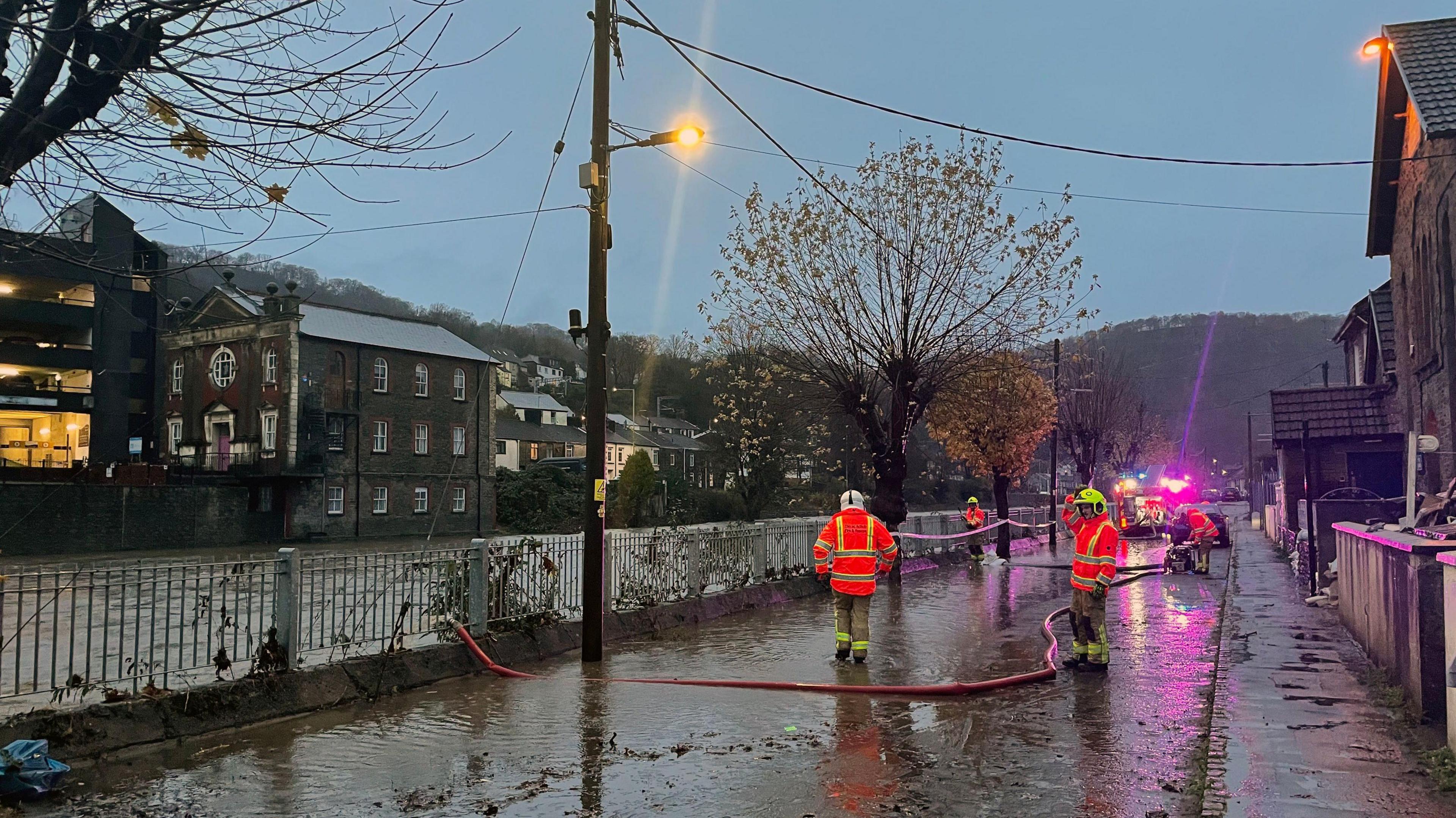 Firefighters pumping flood waters on Sion Street, Pontypridd, Wales.