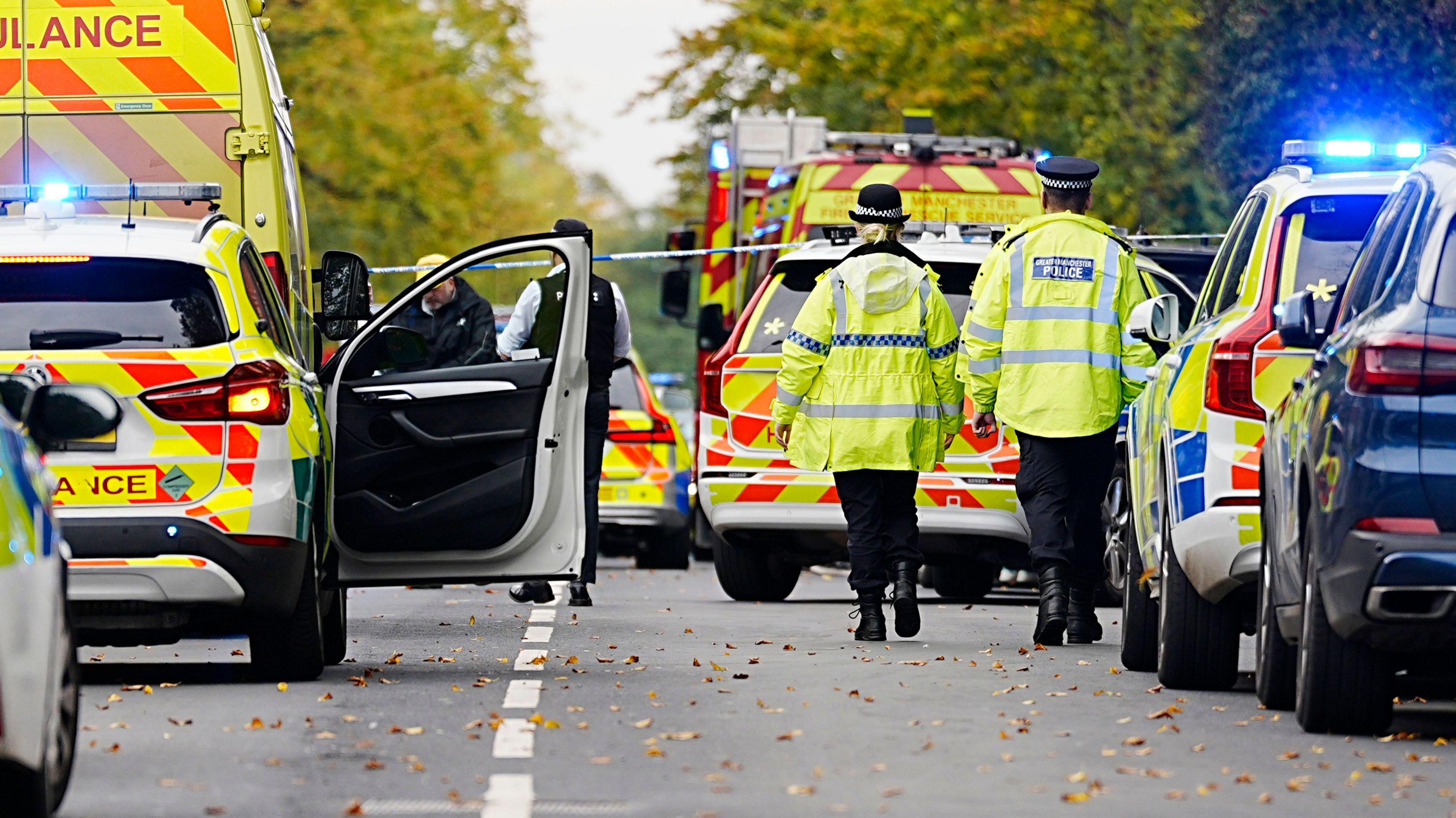 Emergency services including police, ambulance and a fire engine can be seen on a road
