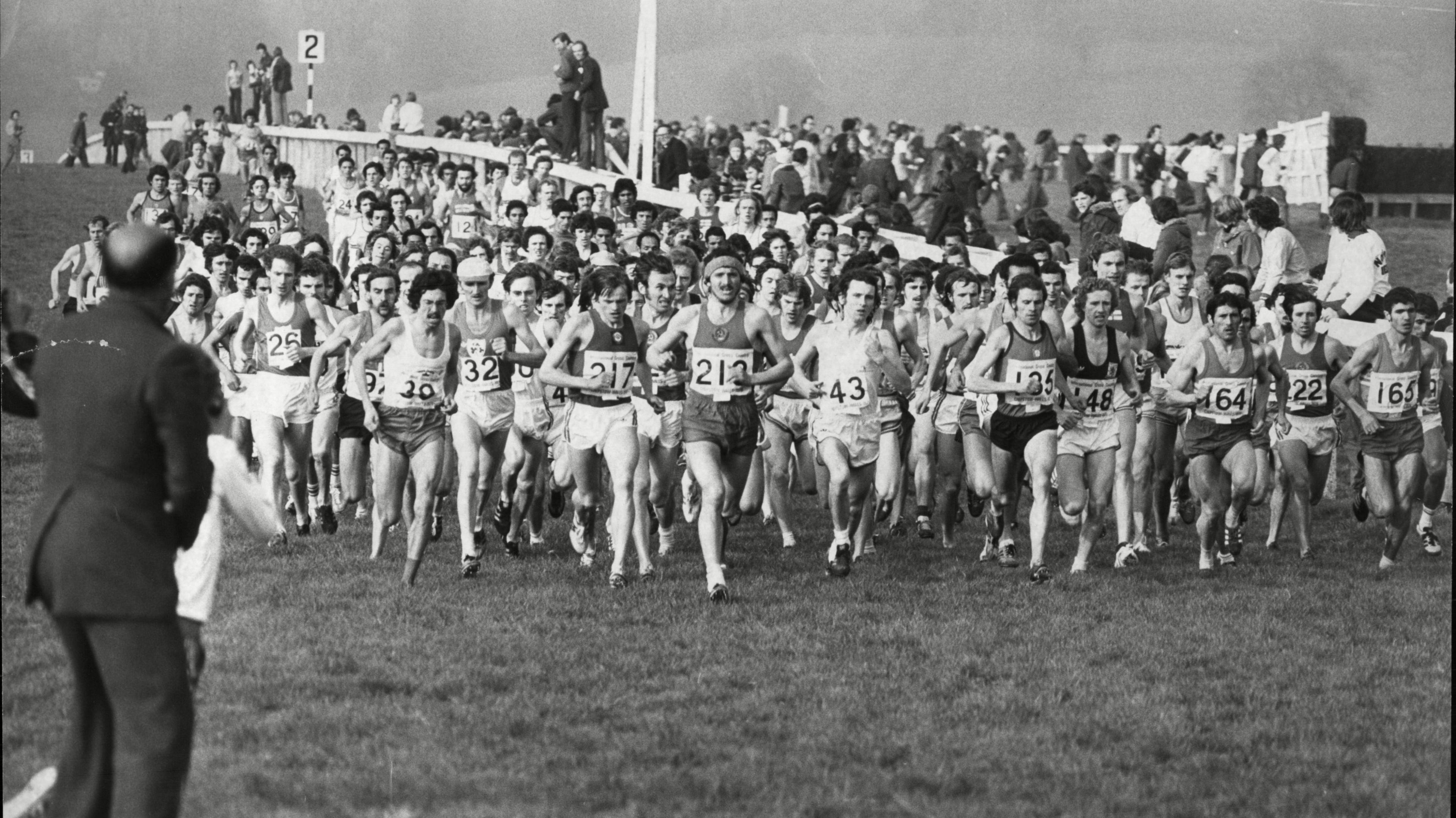 A black and white image of competitors running along the racecourse in 1976