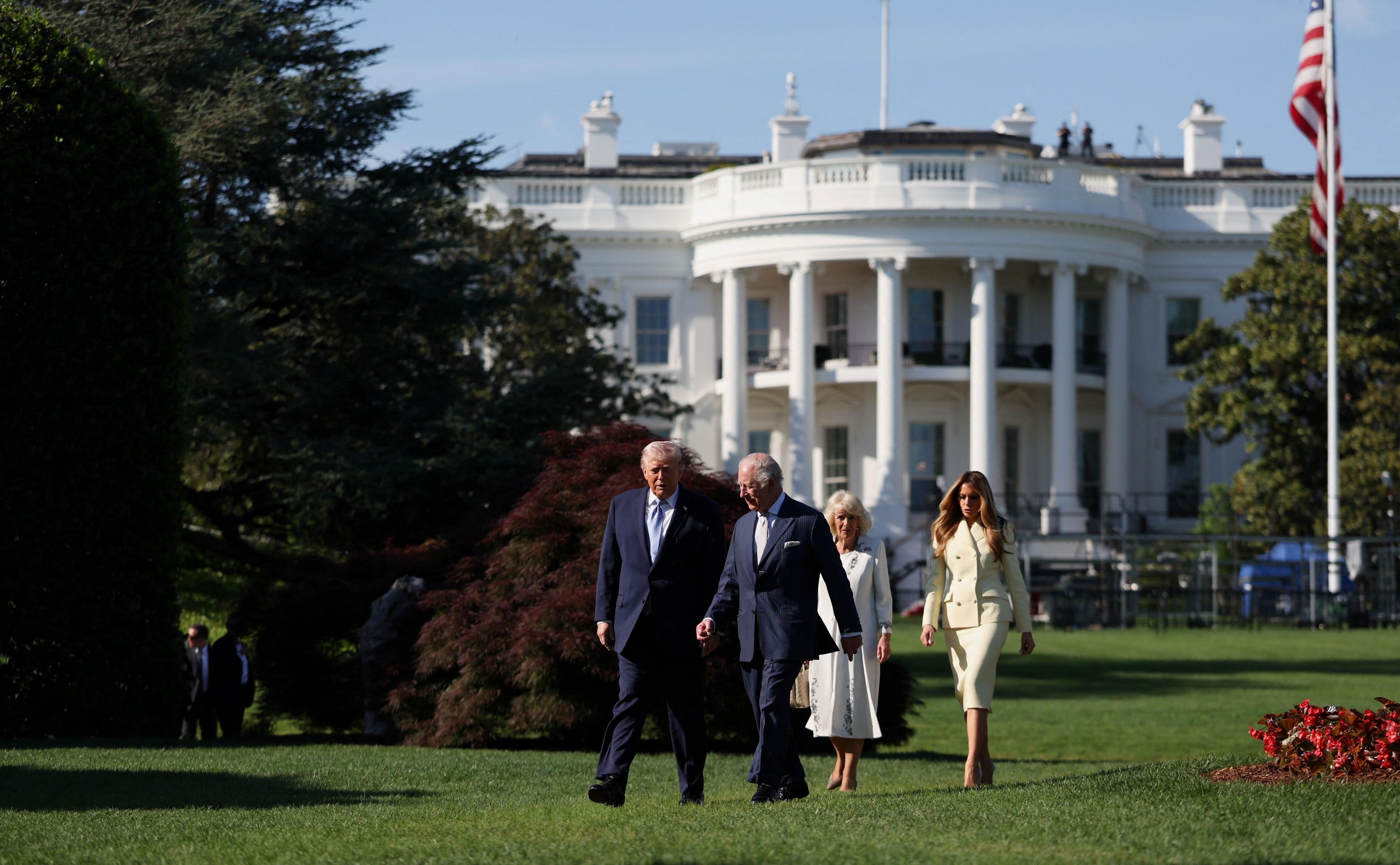 In the grounds of the White House President Trump and King Charles walk together with the Queen and First Lady following behind. 