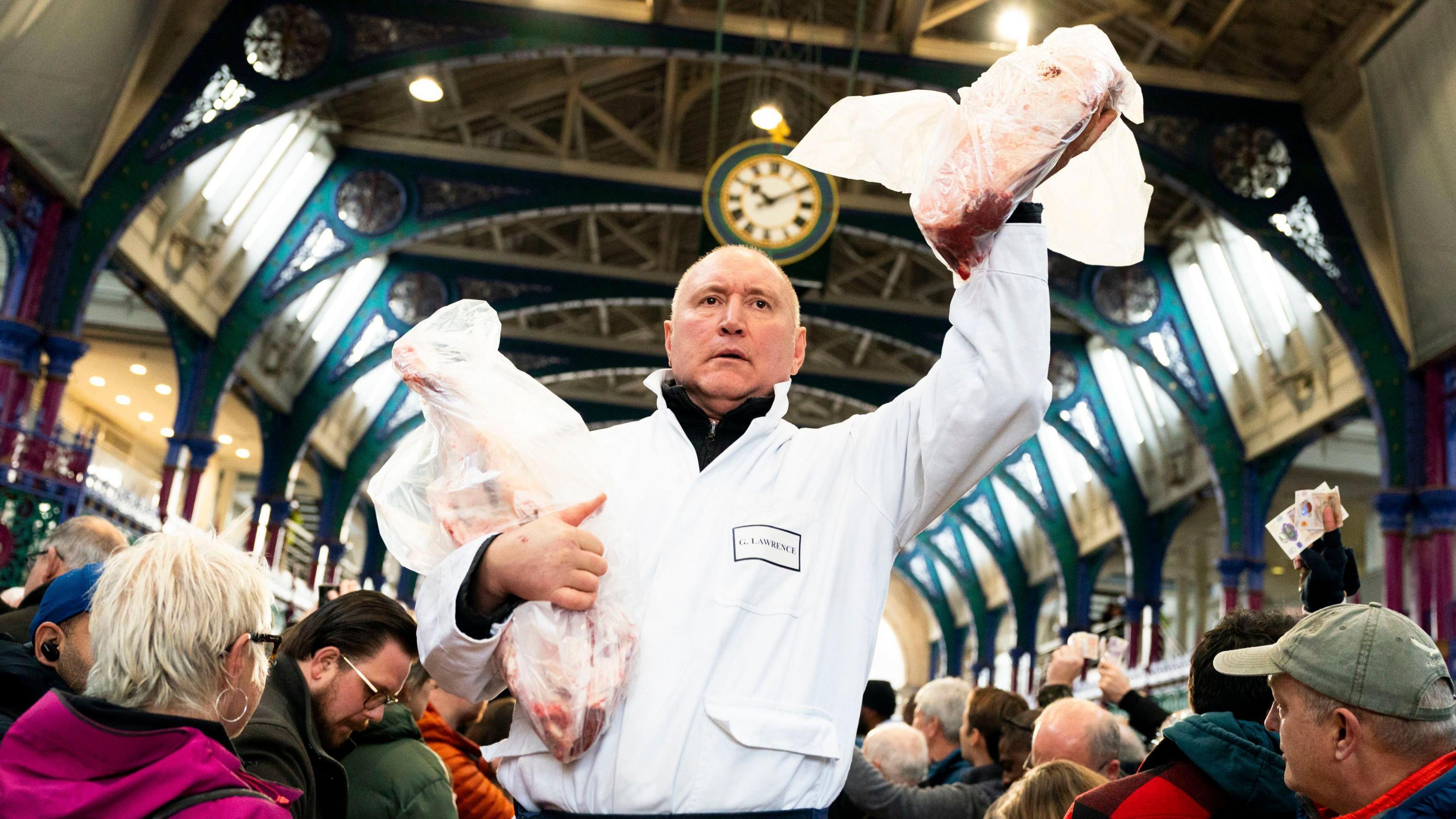 Auctioneer holds up piece of meat