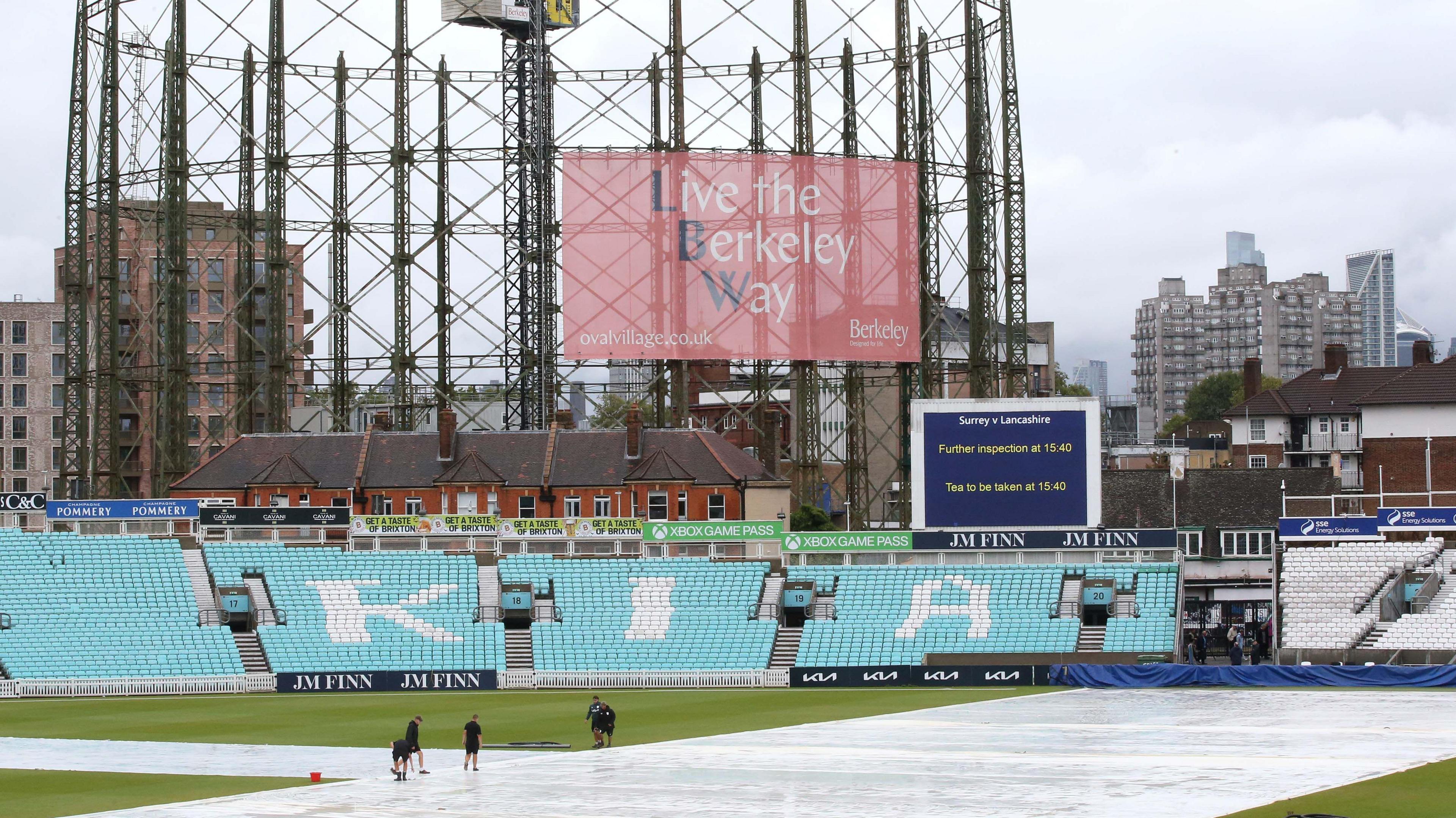 Groundstaff work with the covers on at The Kia Oval