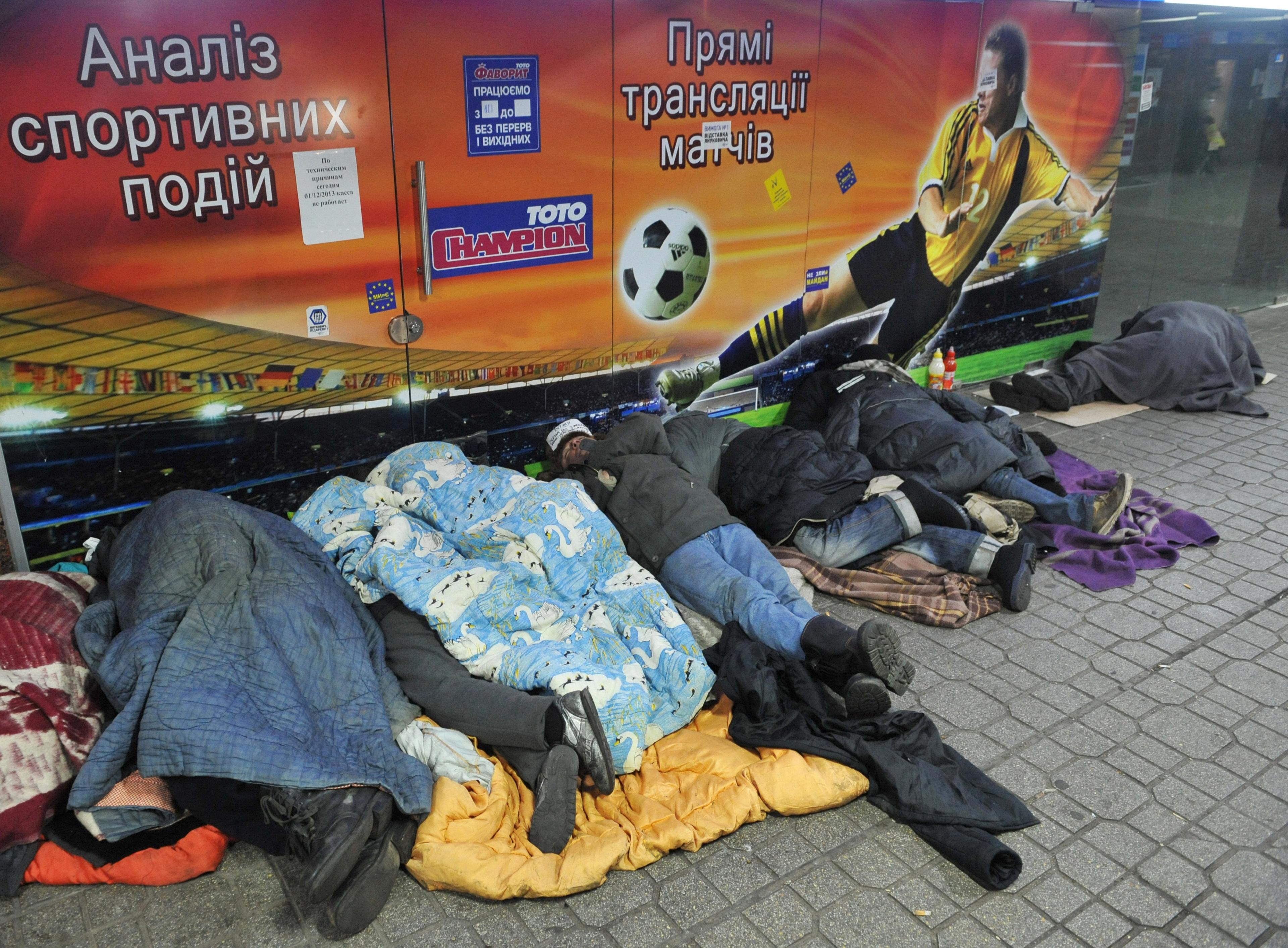 Homeless people sleeping in front of a building in Ukraine's capital Kiev on December 18, 2013.