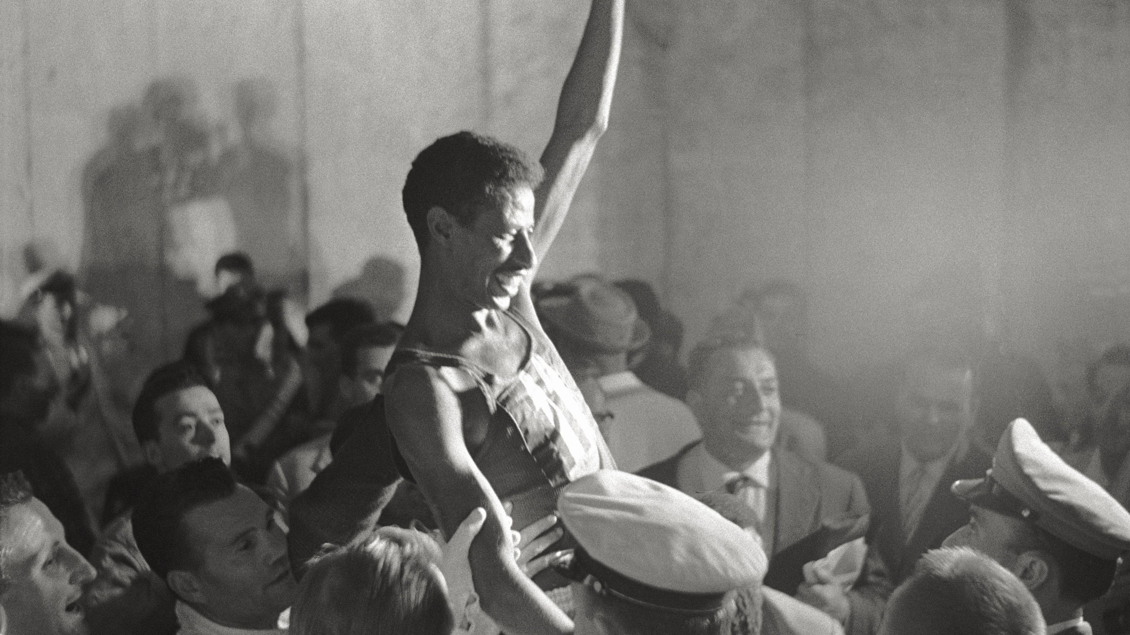 Abebe Bikila is held aloft by a crowd 