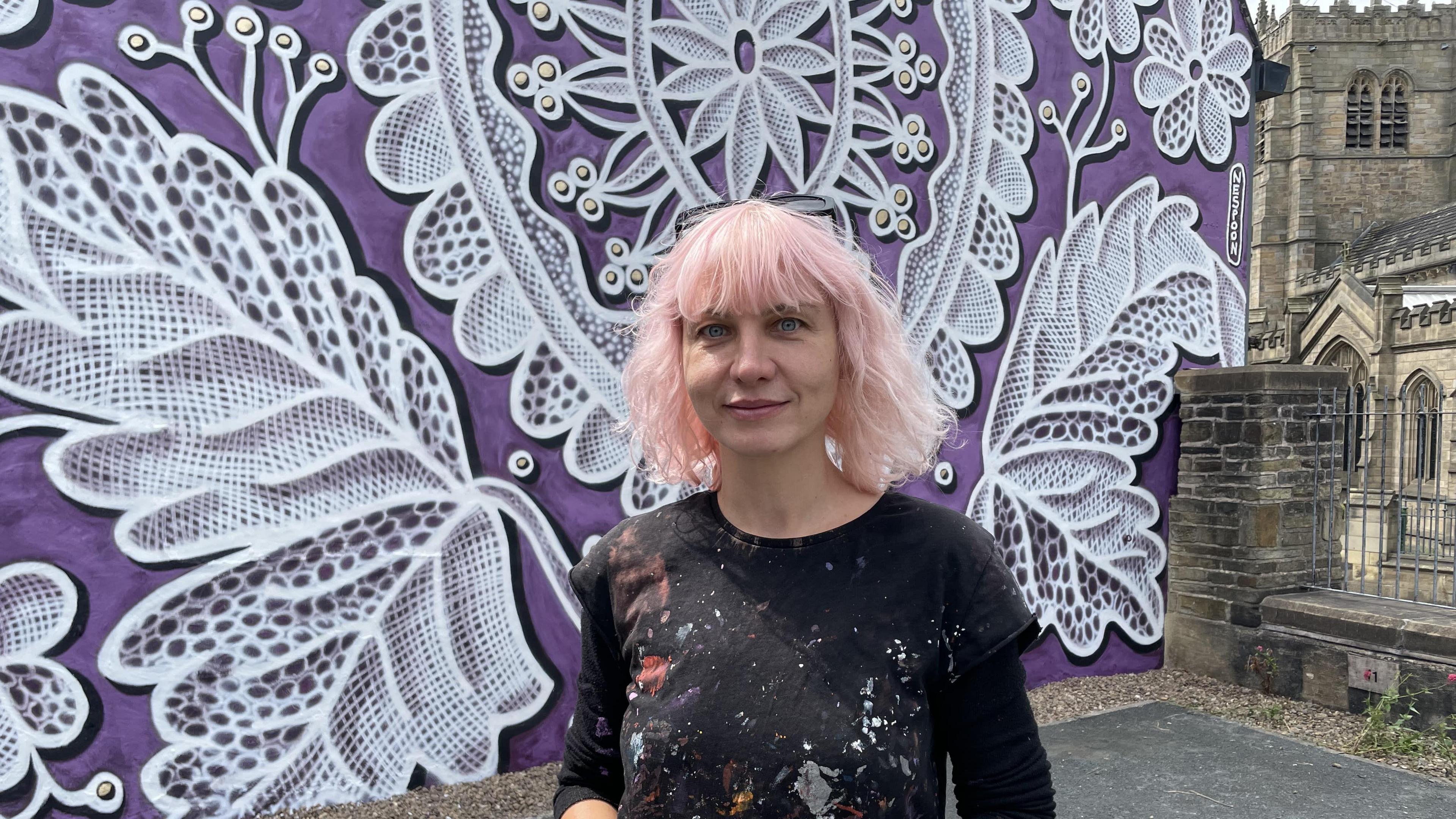 Artist NeSpoon with her lace pattern mural in Bradford 