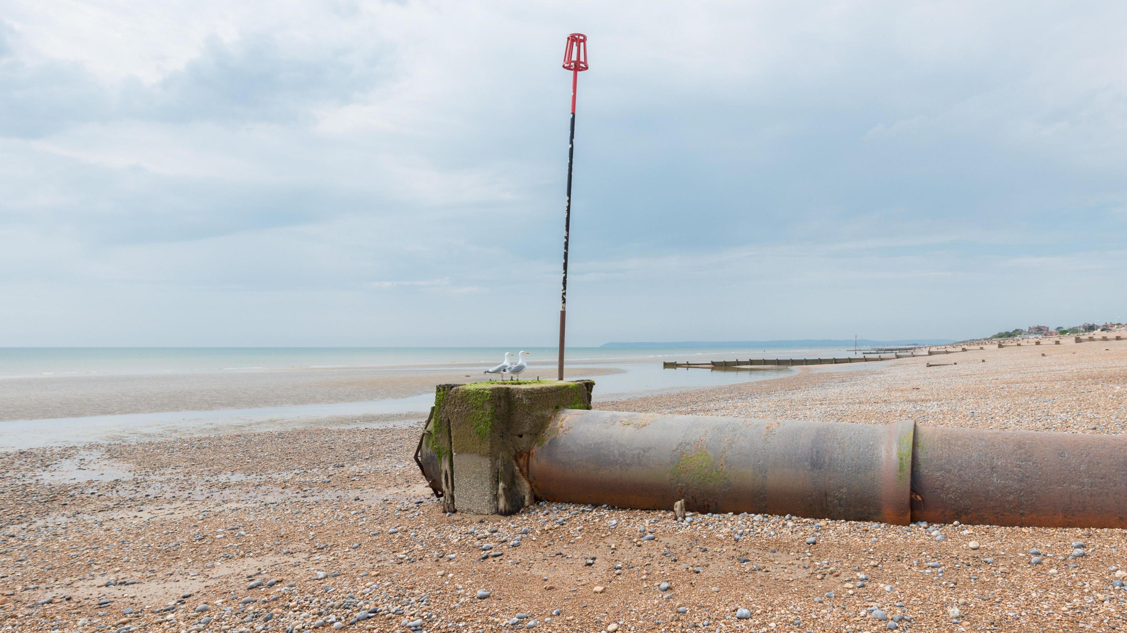 A sewage outlet pipe on a beach