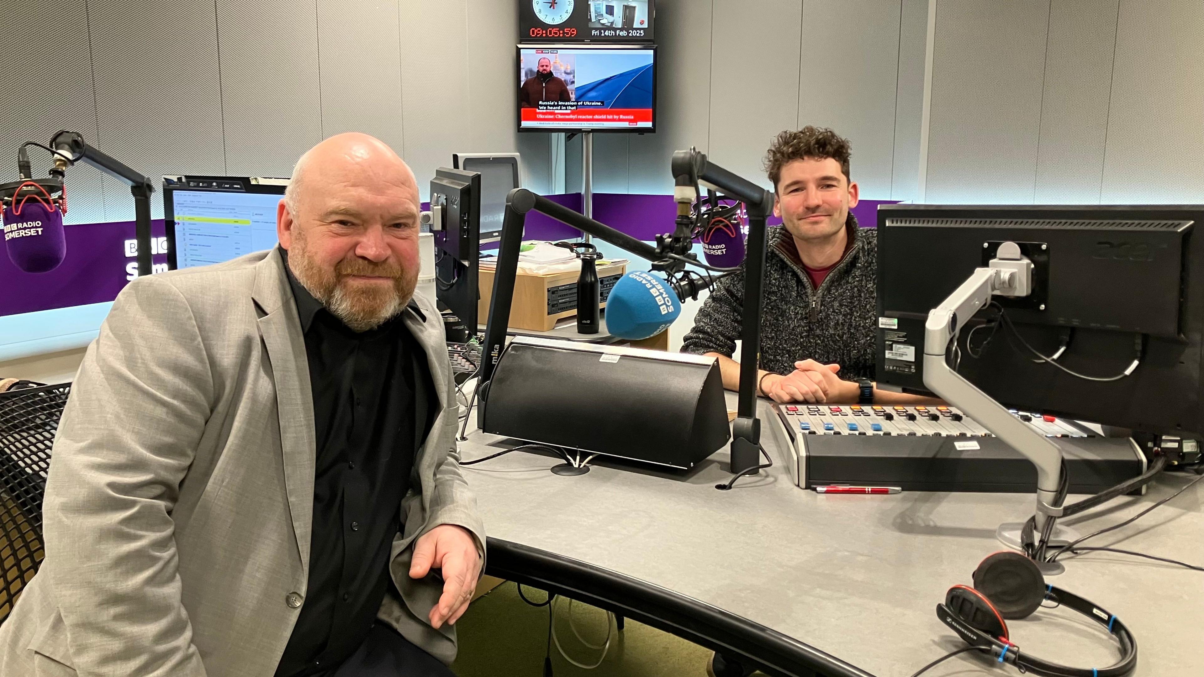 Bill Revans in a radio studio with presenter Charlie Taylor