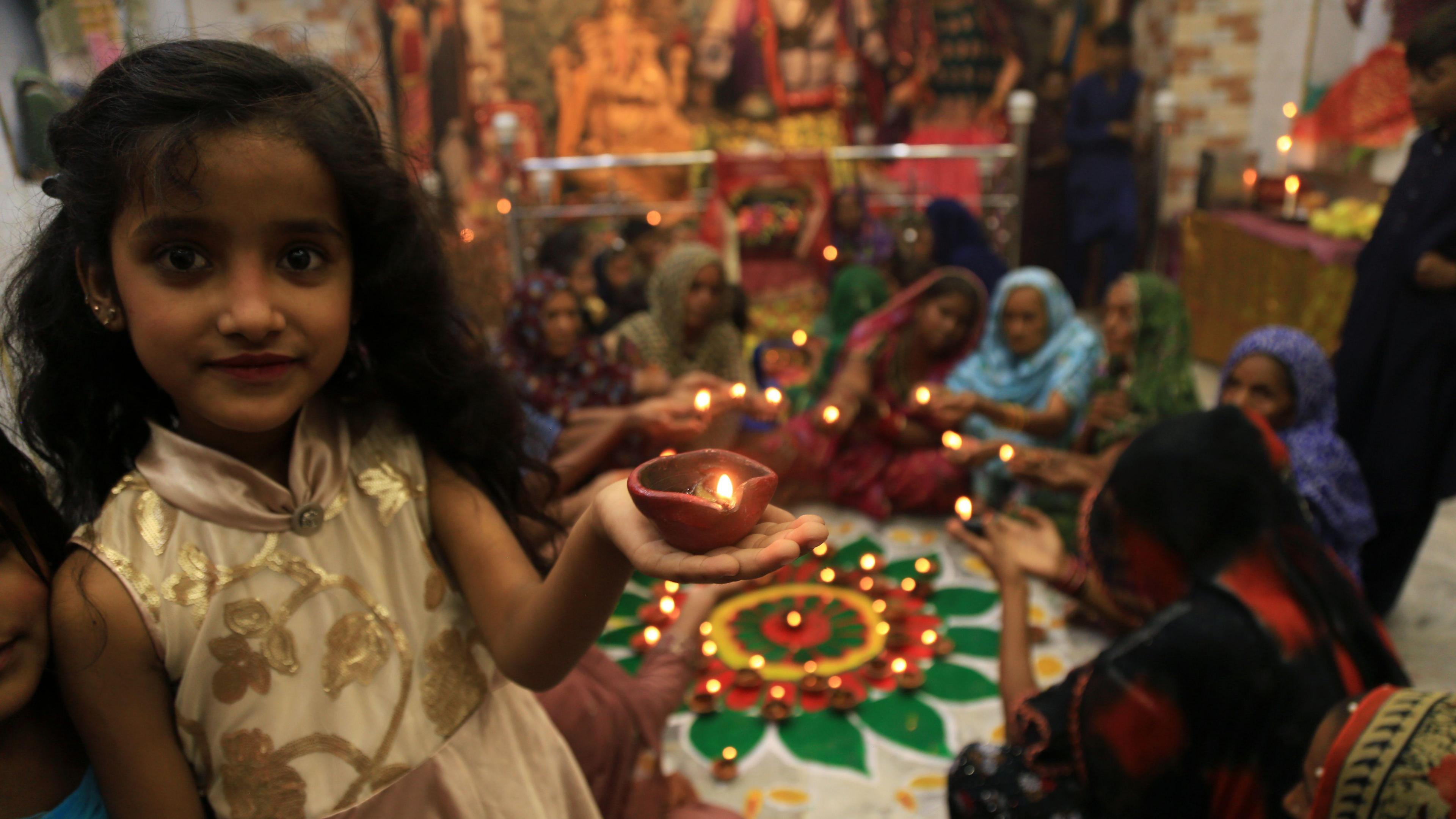 A girl holding an oil lamp.