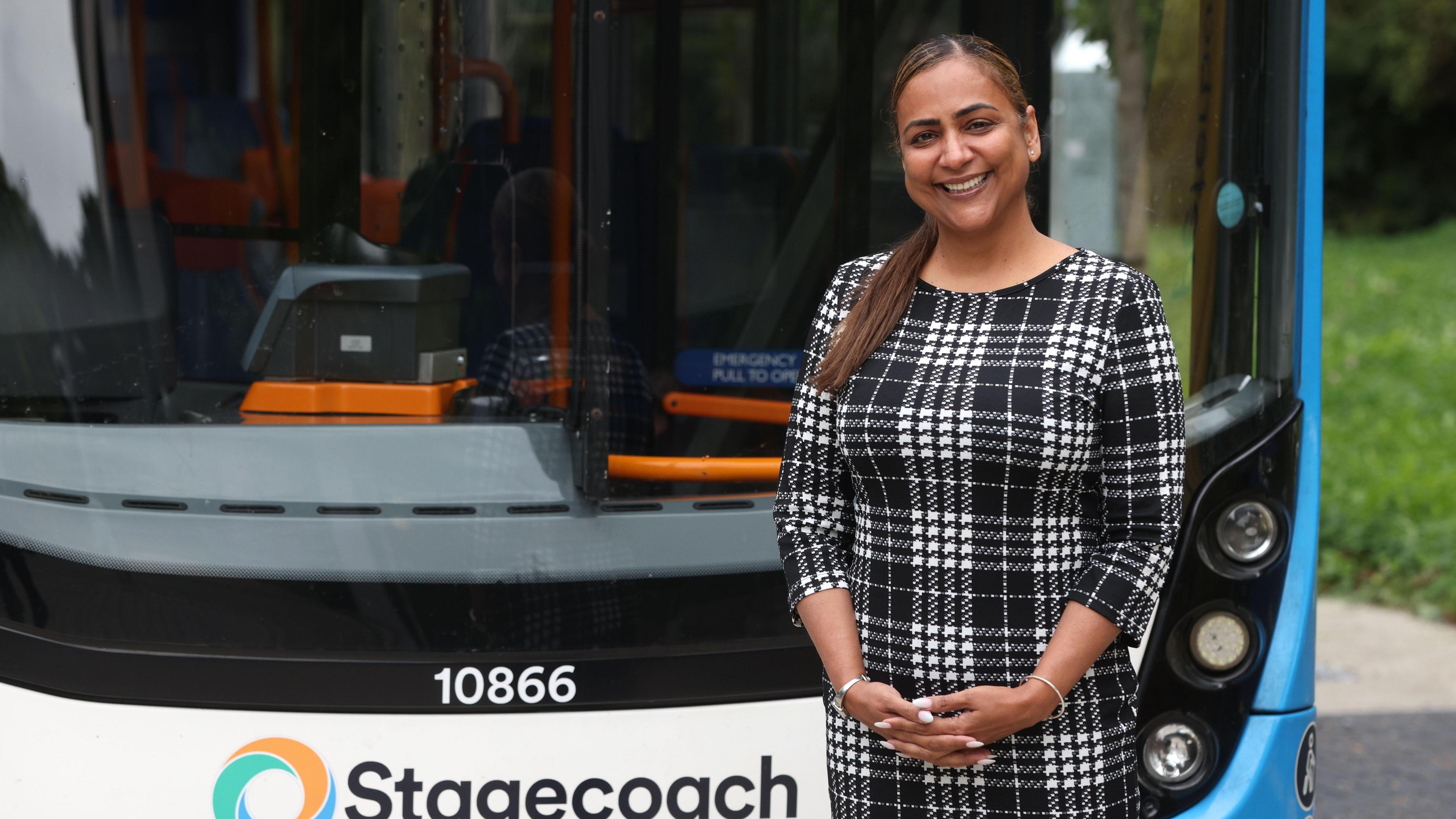 Woman standing next to a Stagecoach bus