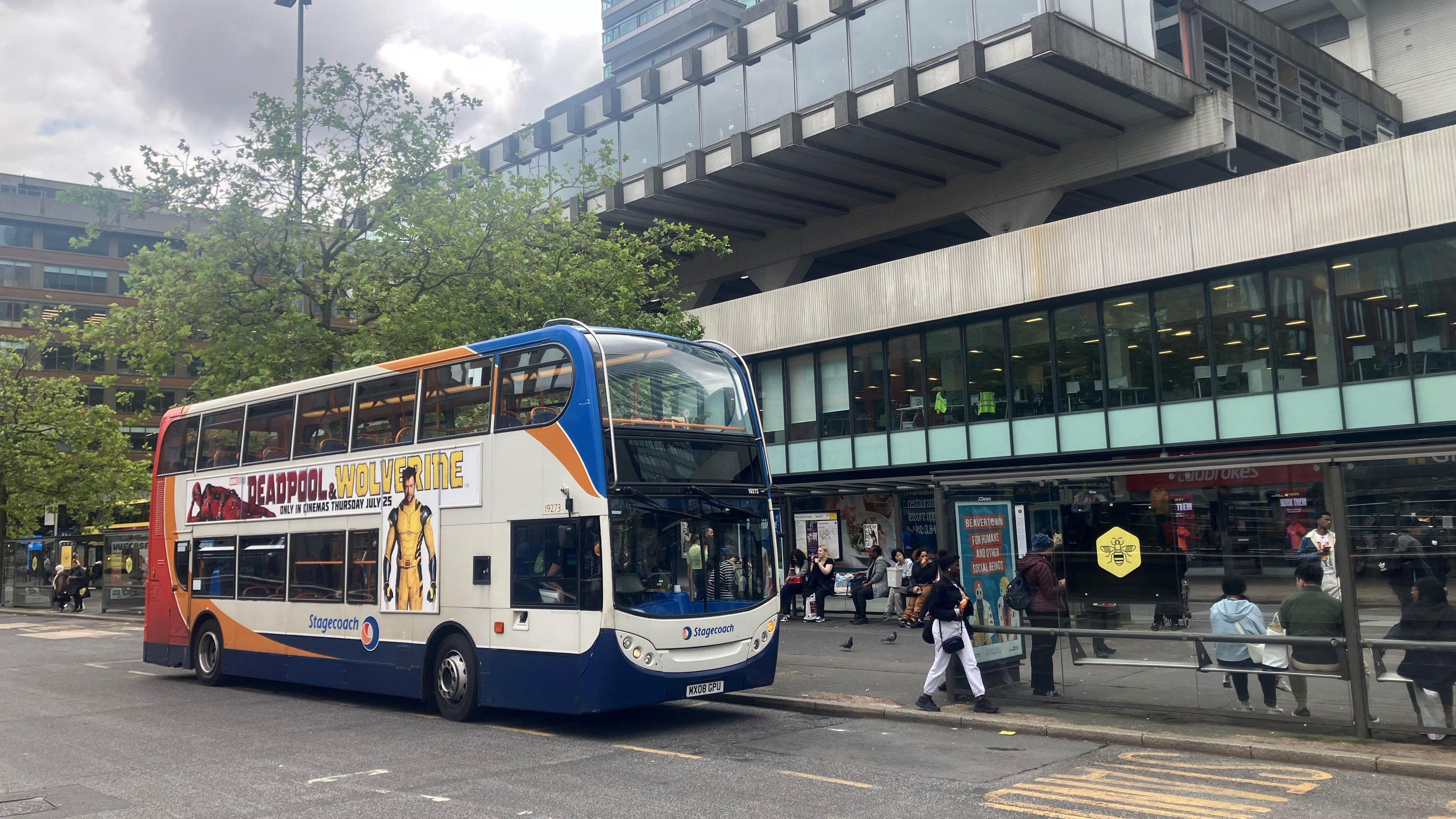 A bus waits in a marked bus stop in Piccadilly Gardens in Manchester