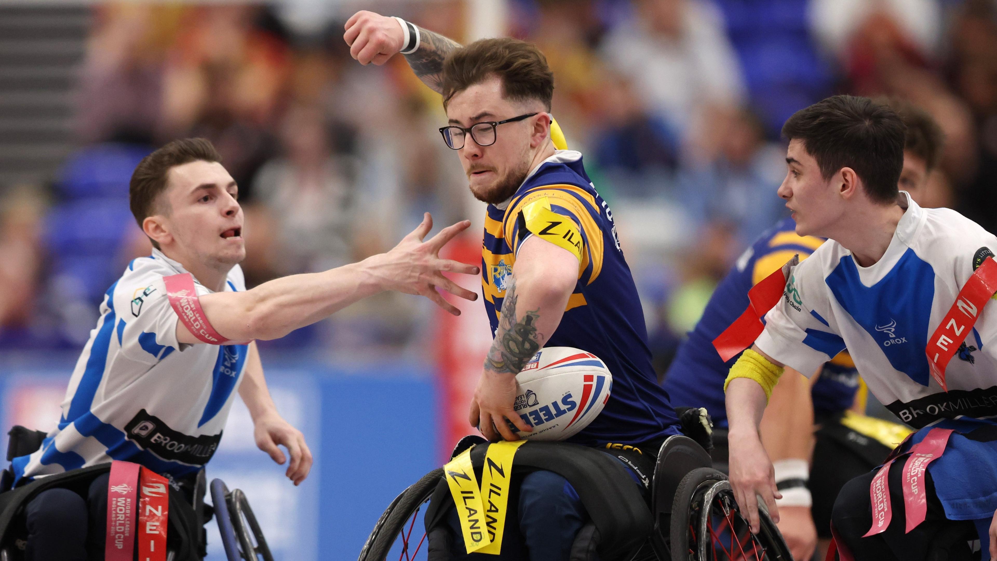 Josh Butler surges between two opponents during Leeds' Wheelchair Super League Grand Final win over Halifax