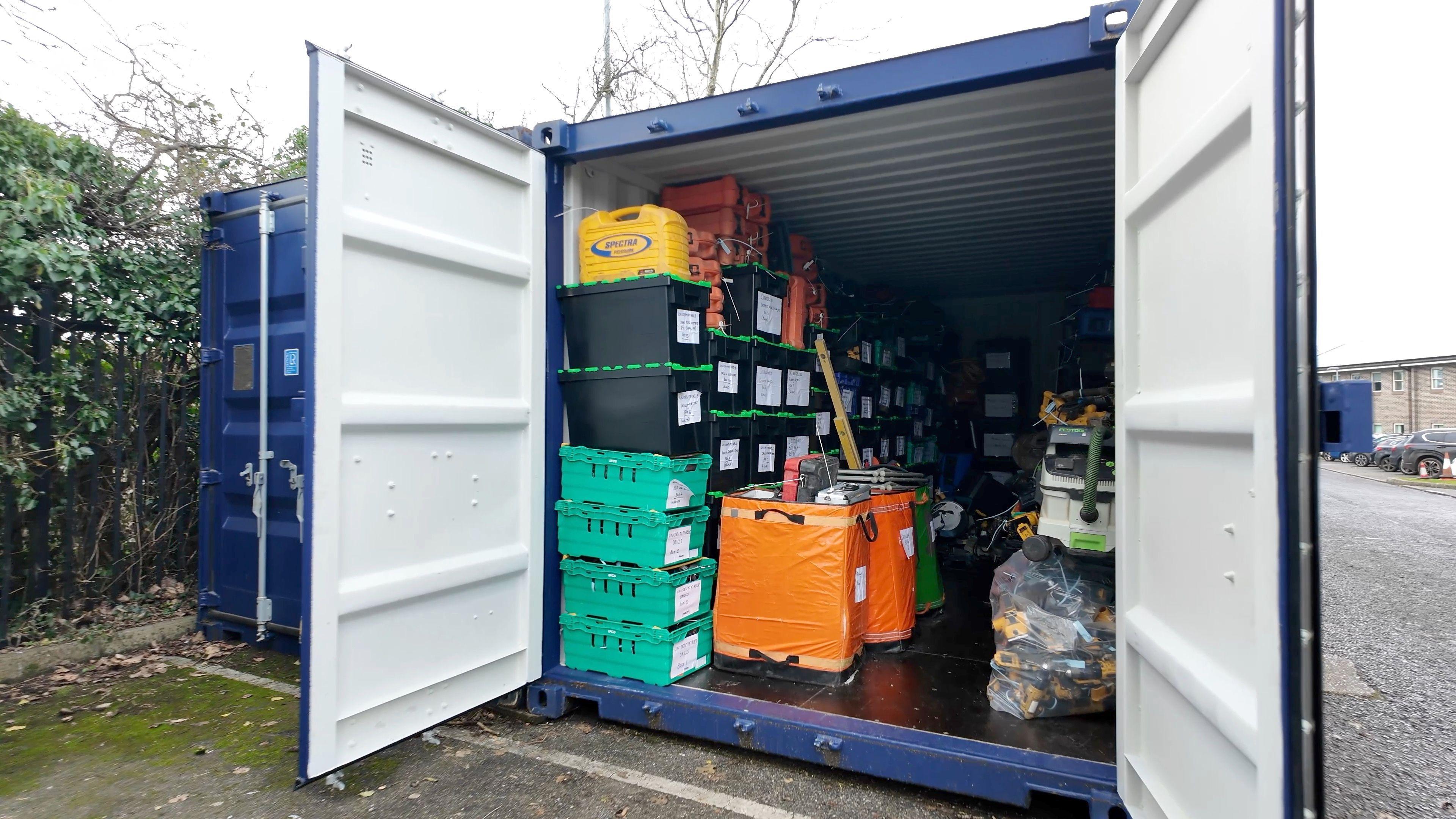 Image of a shipping container with boxes of tools inside. 