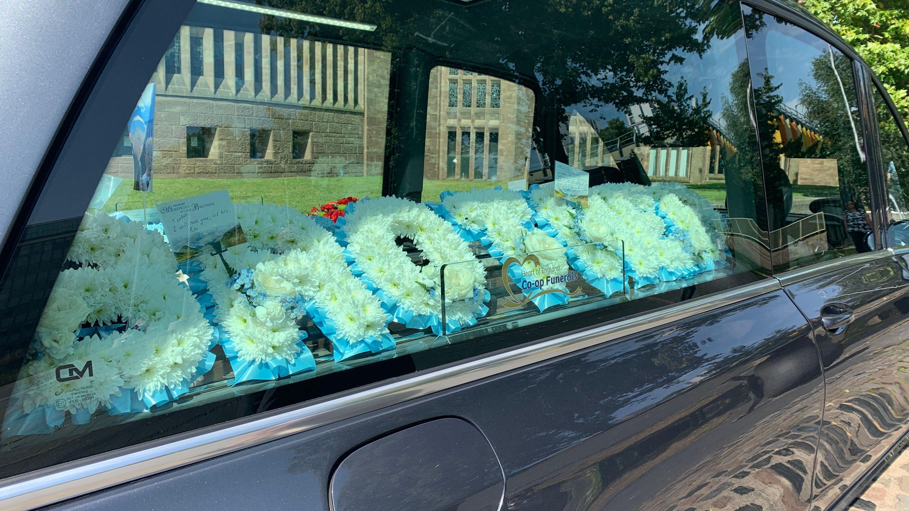 A blue floral tribute sitting in a hearse