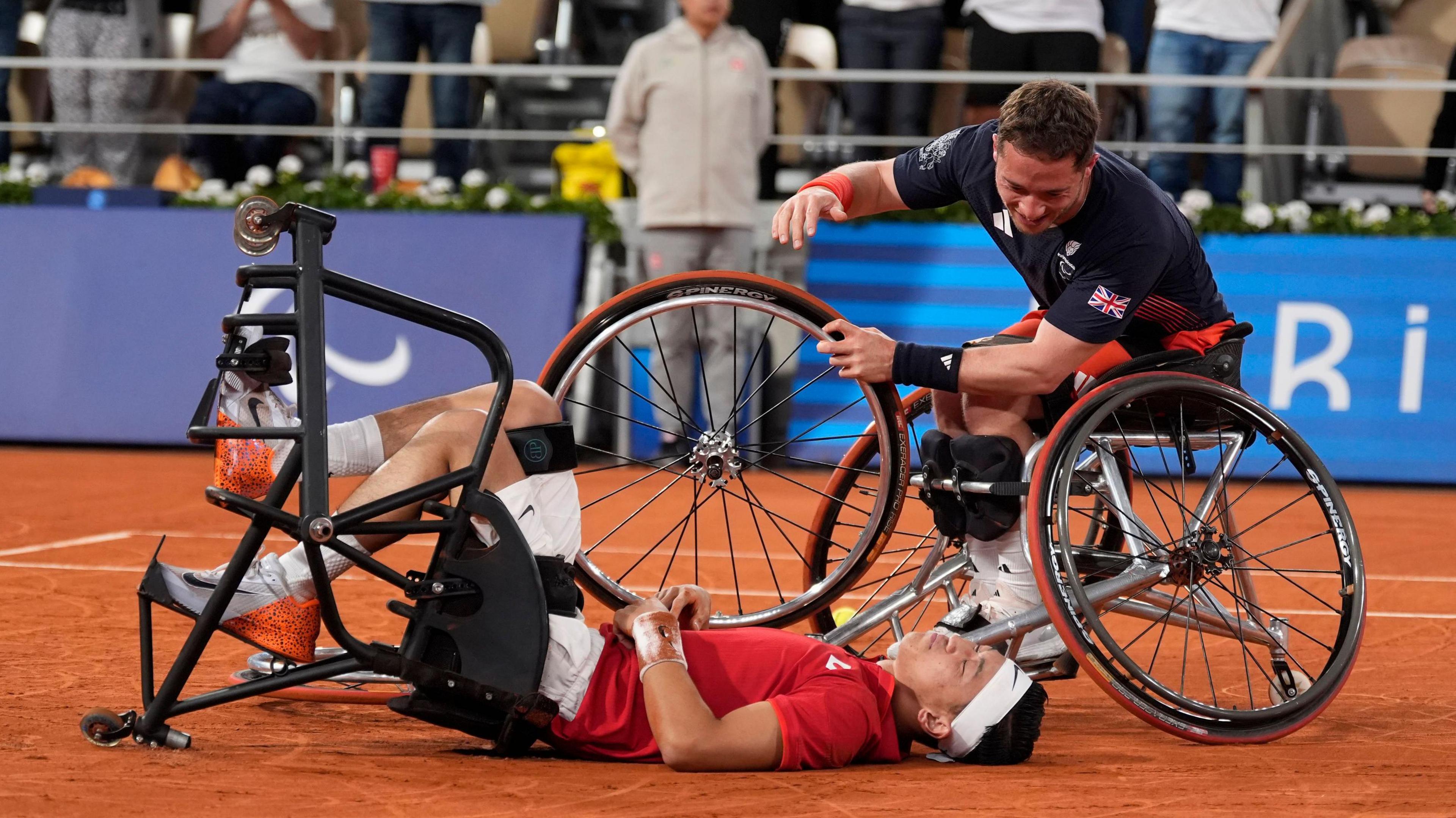 Alfie Hewett comes over to congratulate Tokito Oda, who is lying on his back on the Roland Garros clay, after the Paralympic wheelchair tennis singles final