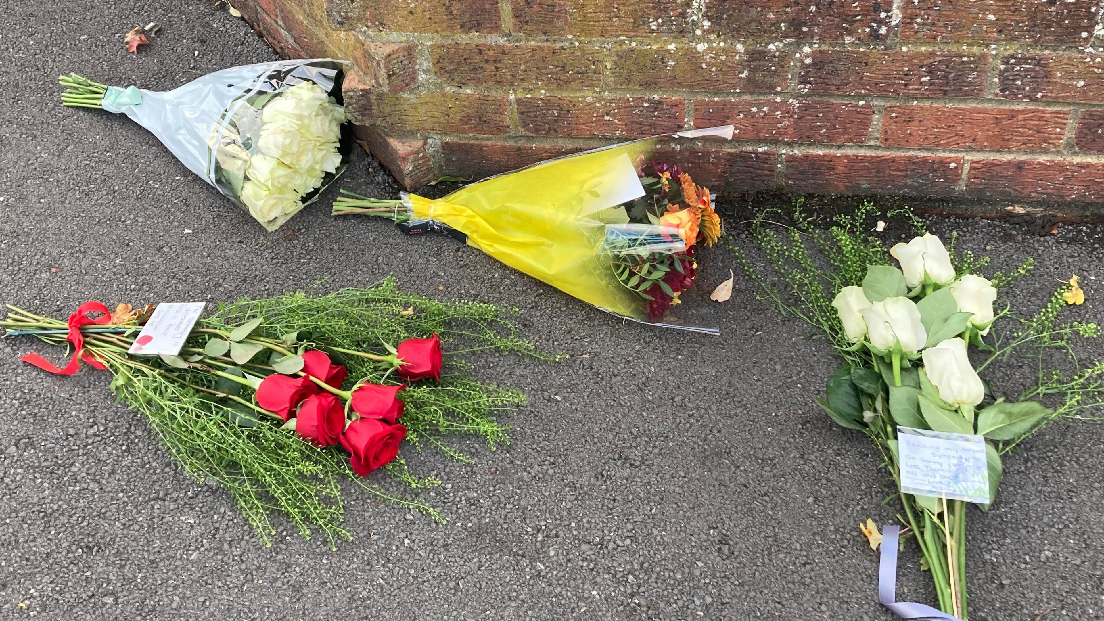 Four bunches of flowers at the scene in Midhurst Gardens in Uxbridge.