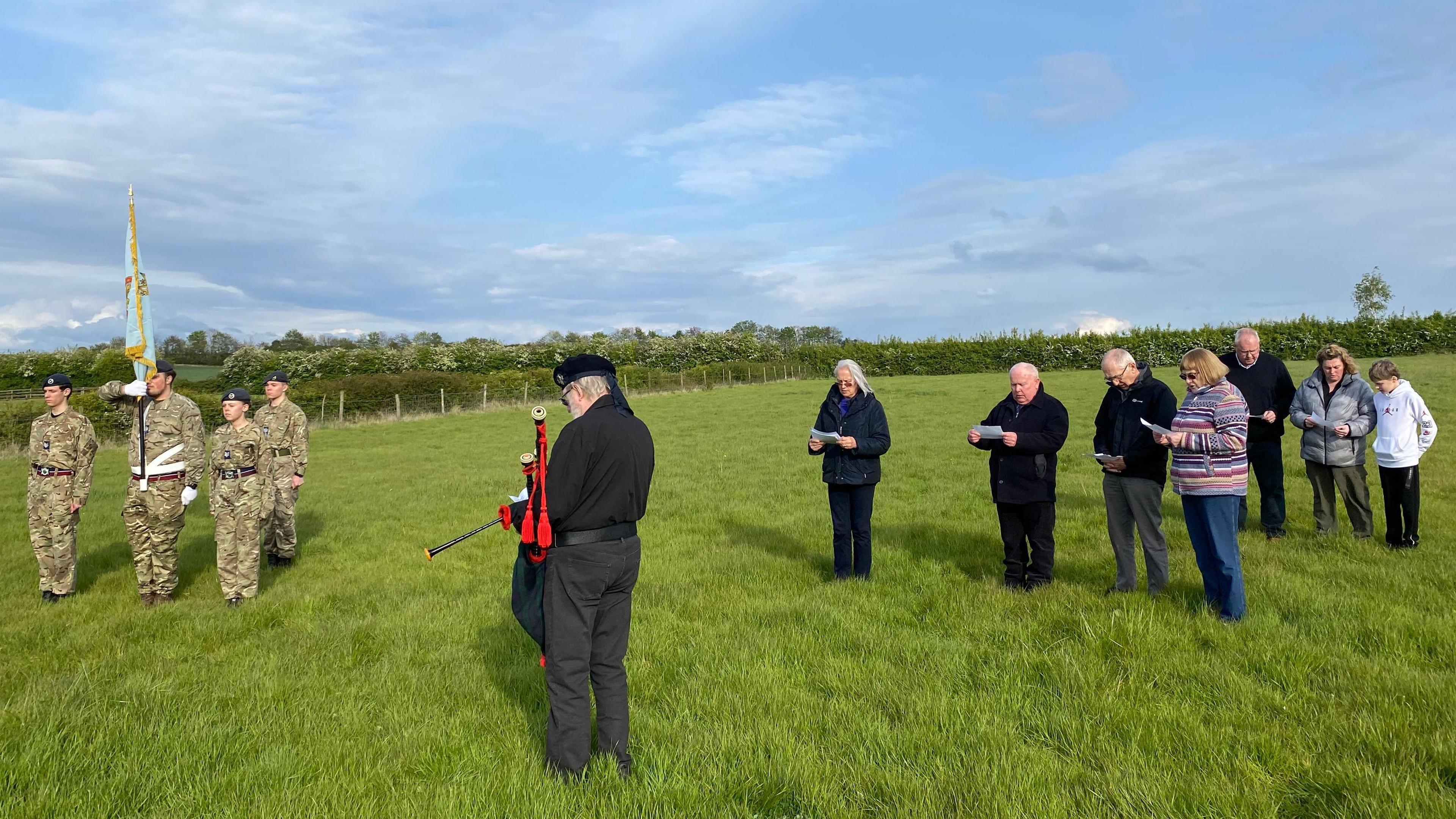 People gathering in a field for the memorial