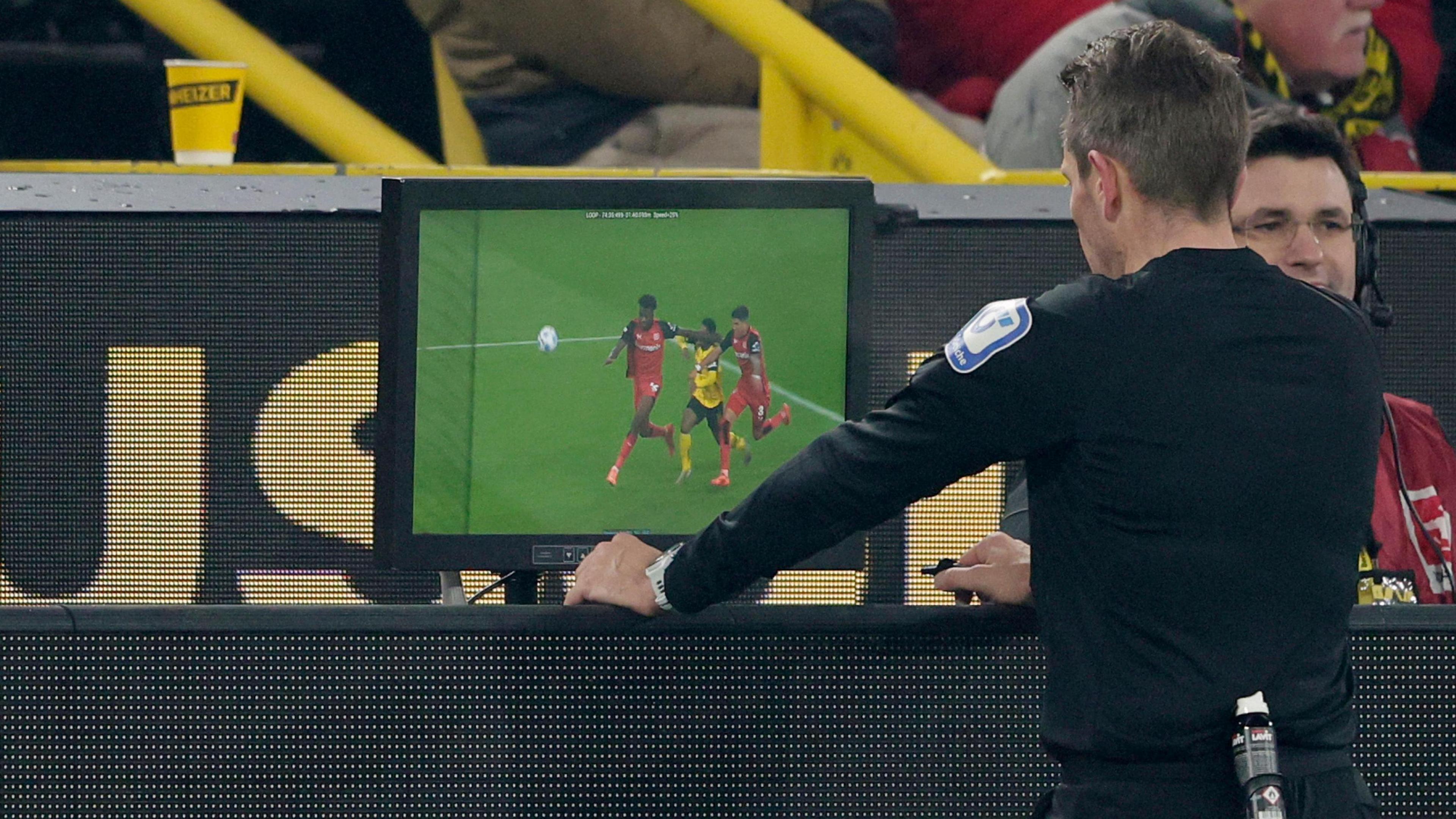 A match official looks at the VAR screen during a game between Bayer Leverkusen and Borussia Dortmund