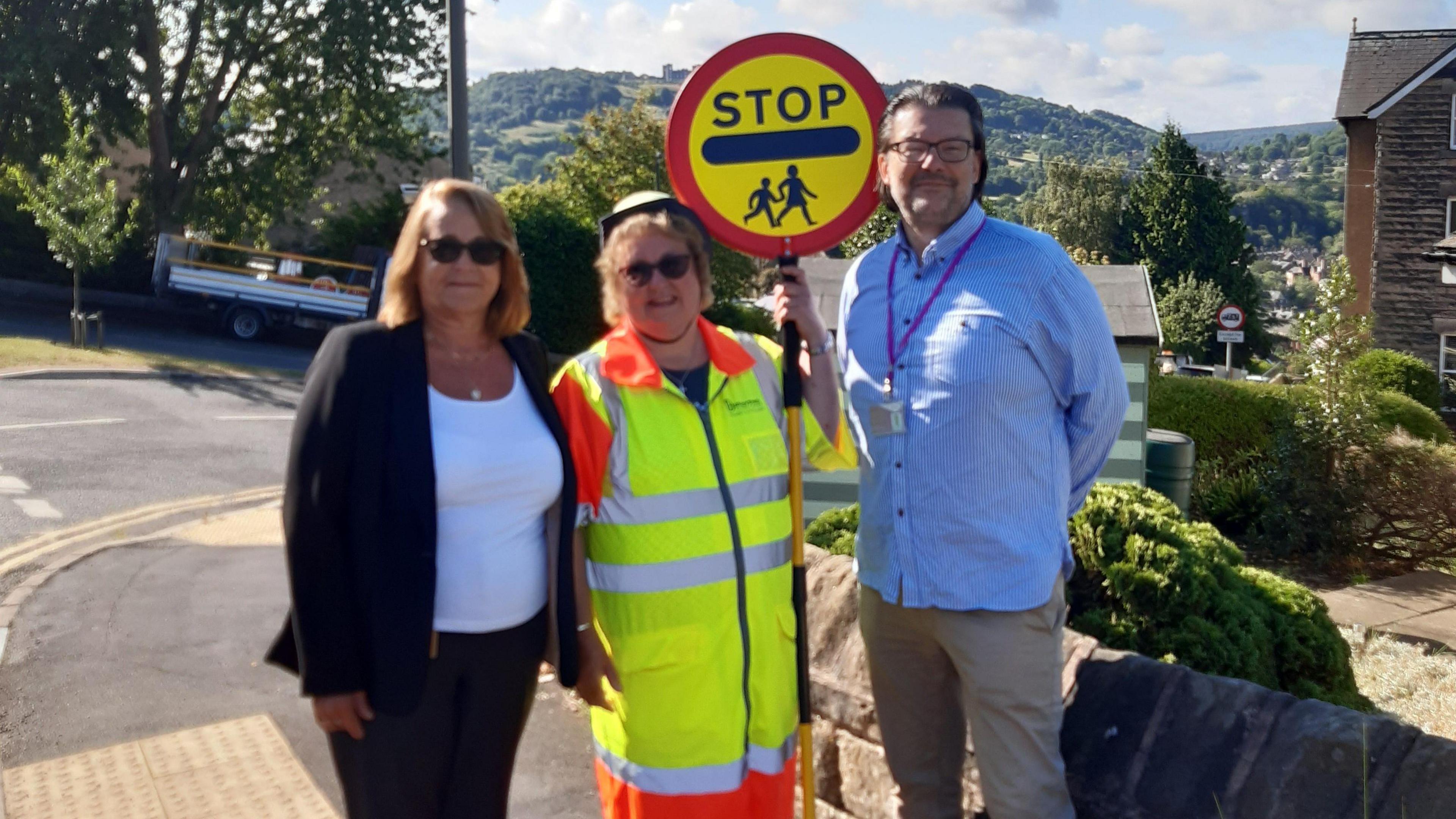Denise Elliot in her crossing patrol gear with two council officials on each side