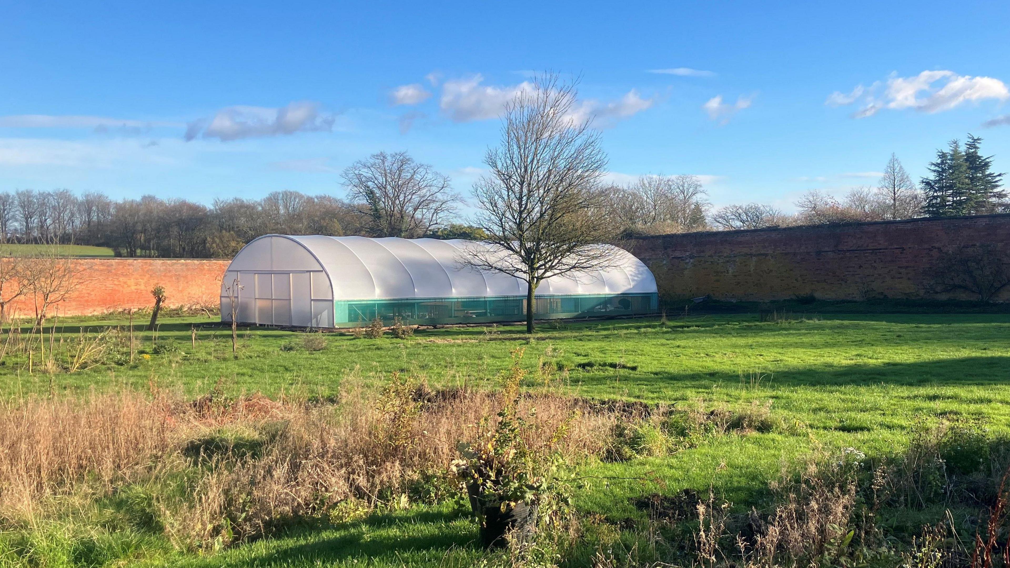 The walled kitchen garden at Haigh Hall in Wigan. Victorian brickwork can be seen surrounding a polytunnel for growing vegetables.