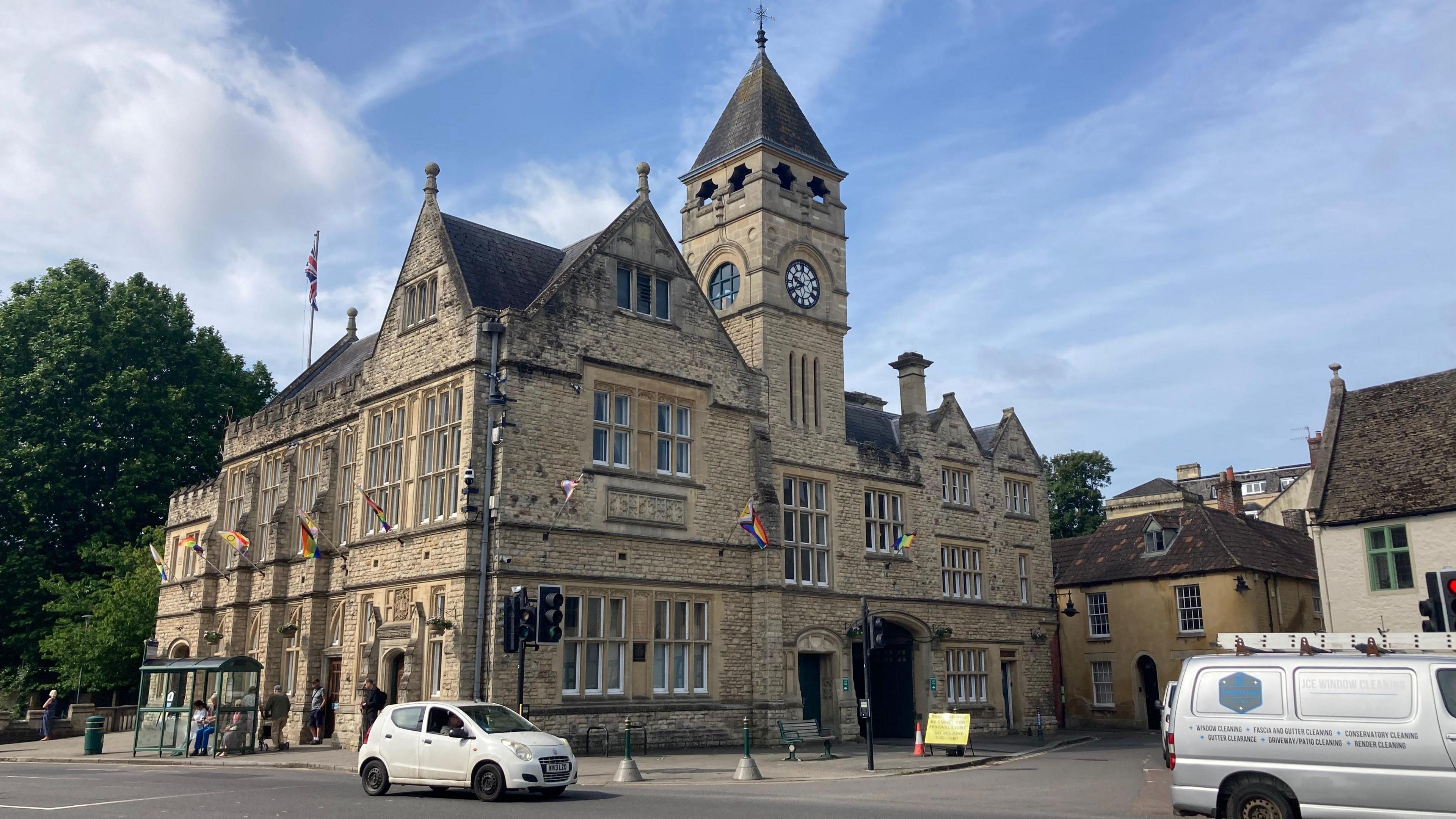 Calne's town hall with clocktower and road alongside on a sunny day.