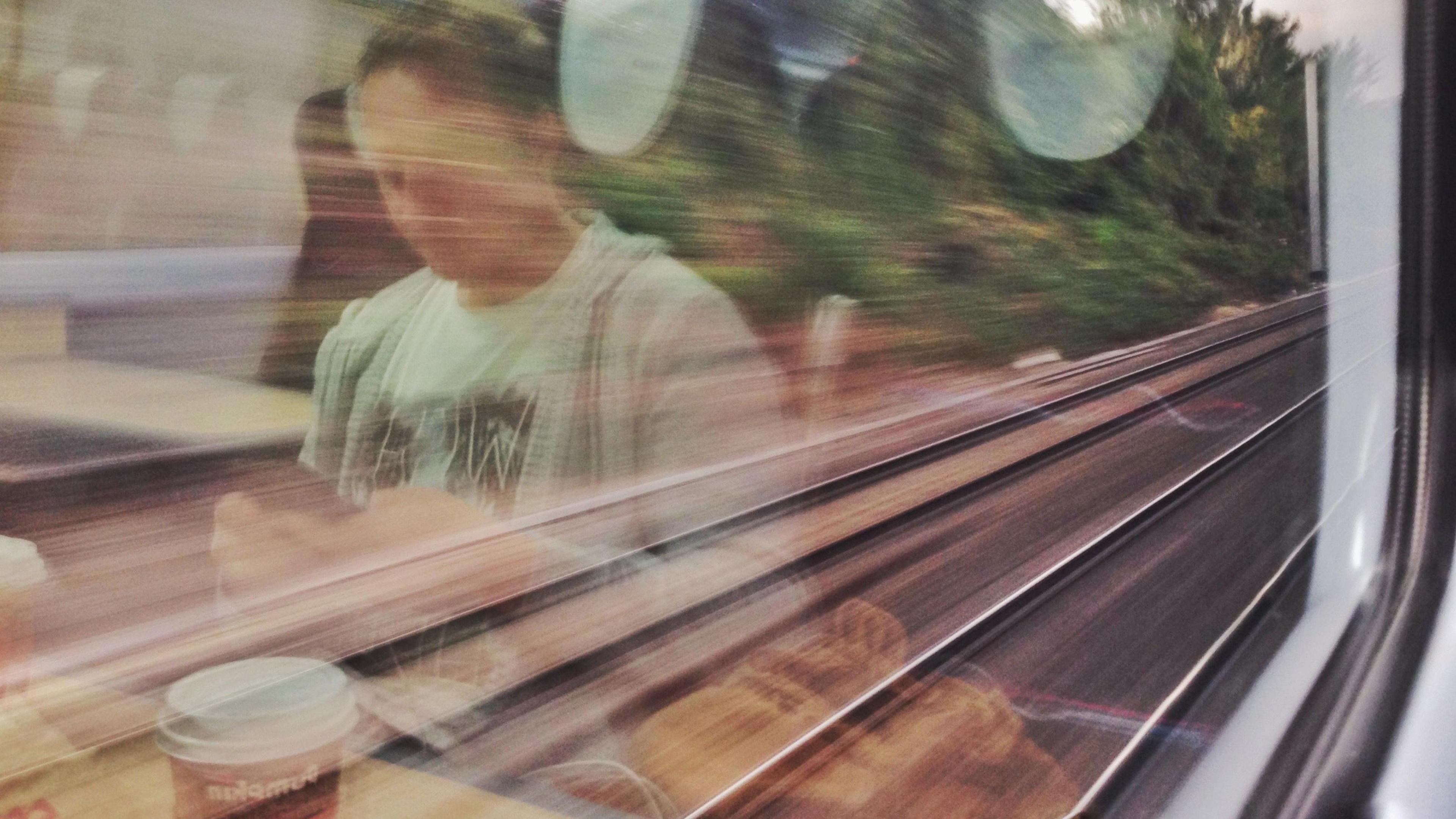 Reflection of a man using his mobile phone on a train 