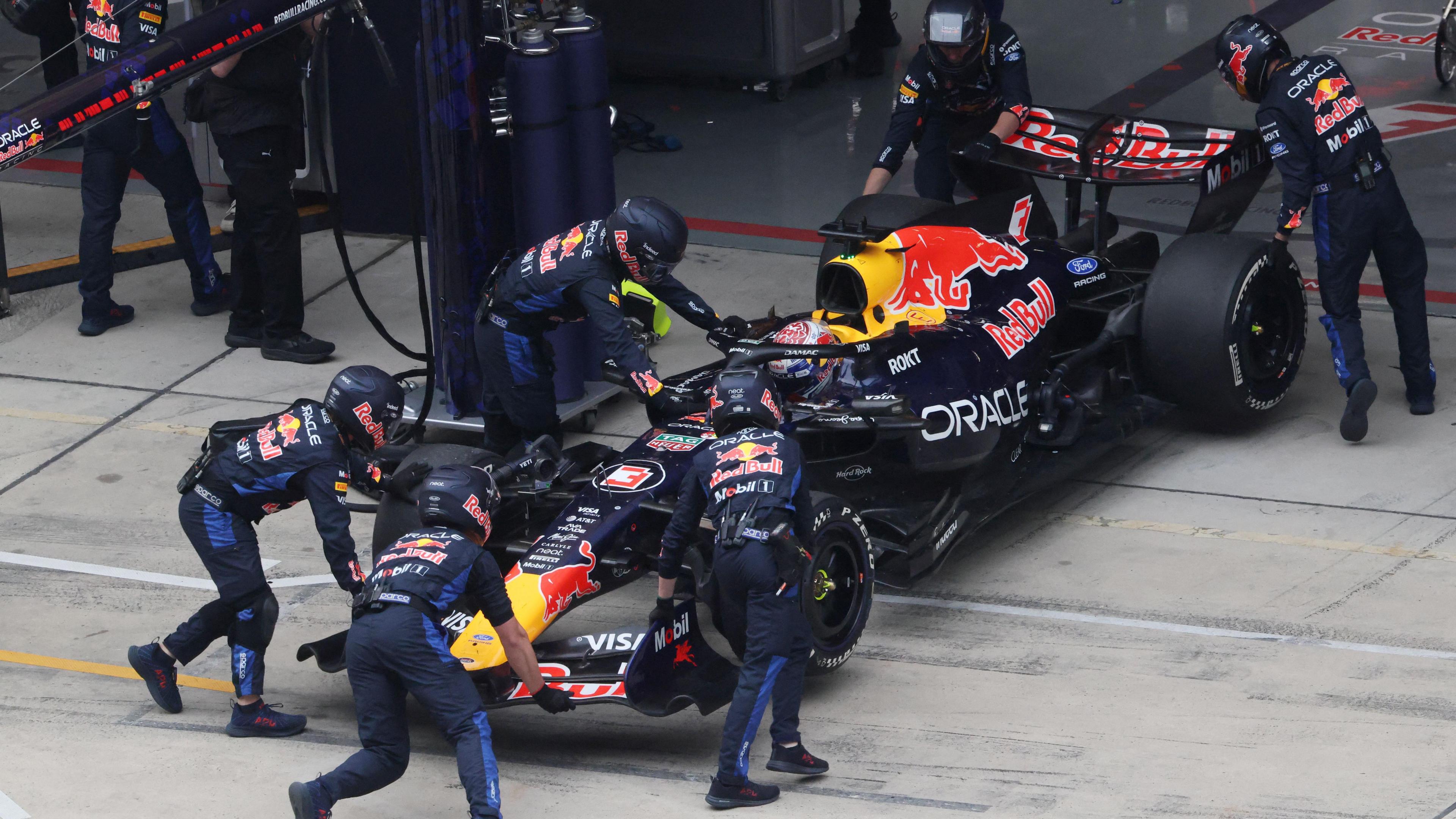 The Red Bull of Max Verstappen is pushed into the garage by team mechanics as he retires from the Chinese Grand Prix