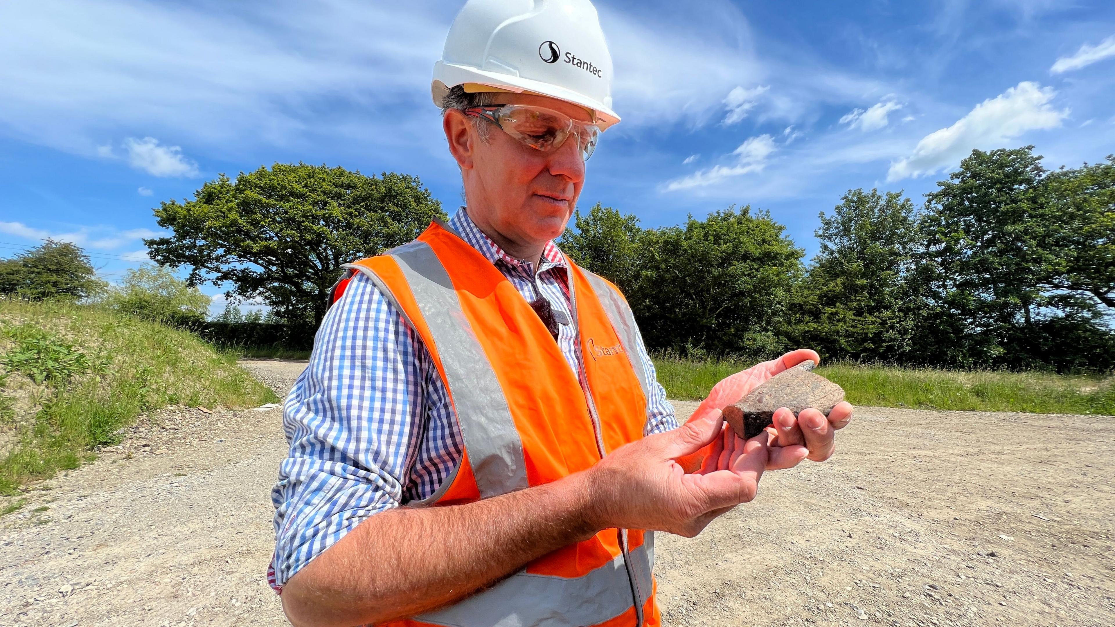 Tim Haines, senior archaeologist, looking at a piece of pottery