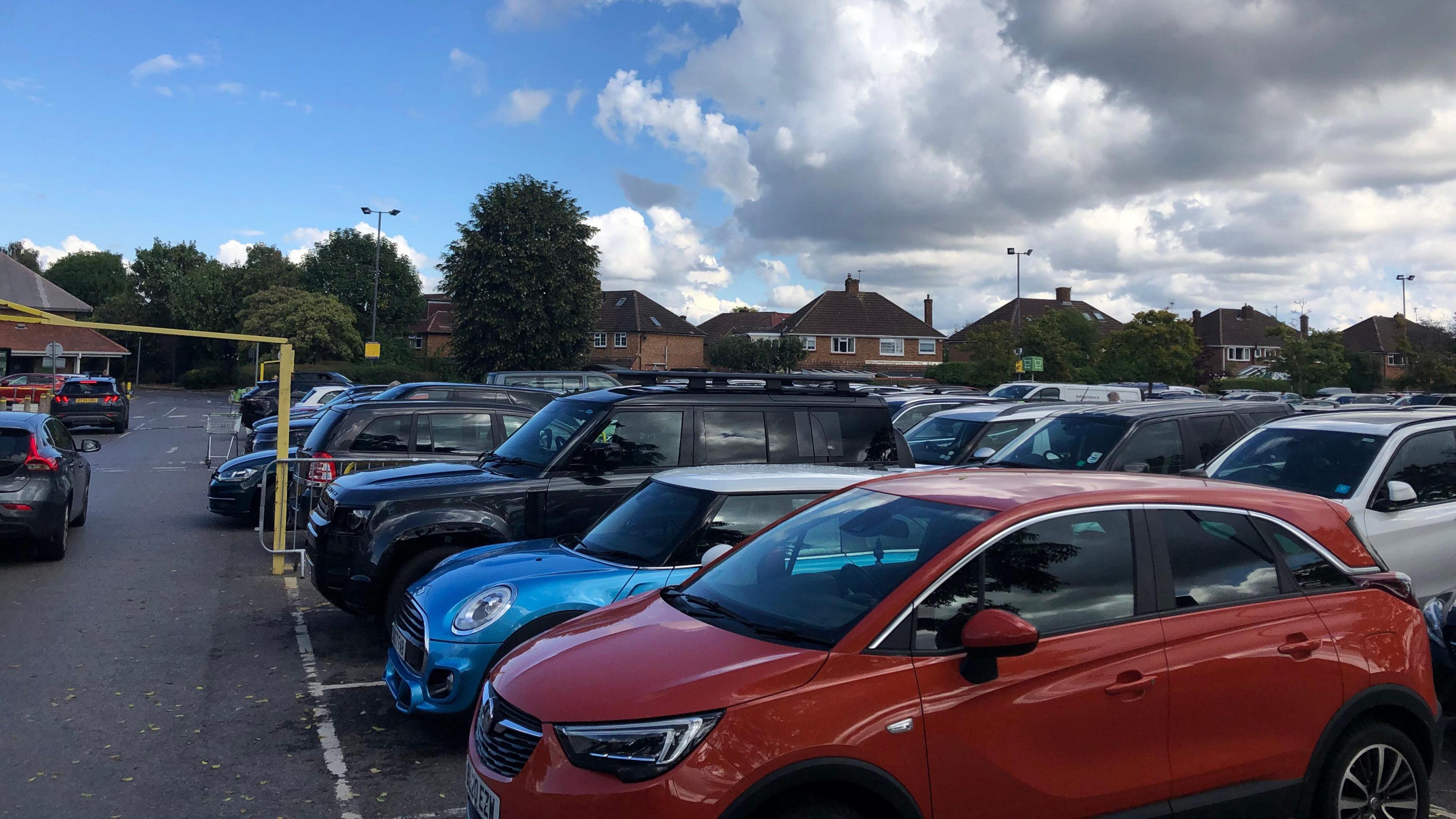 A car park at Hersham Shopping Centre, packed with cars