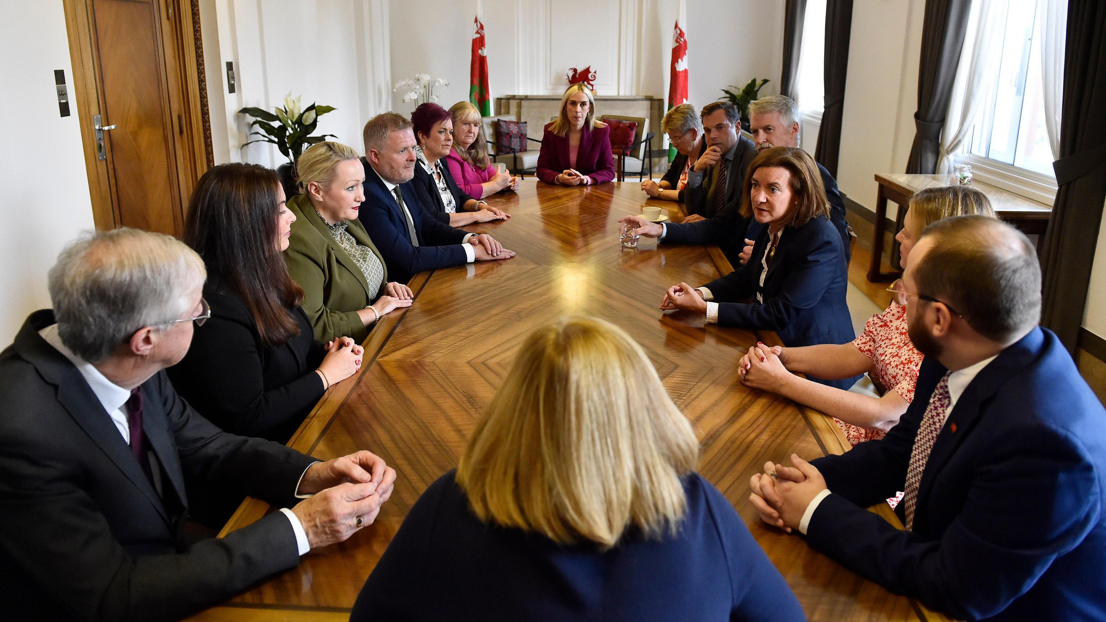 A general view of the ministers of the Welsh government, sat at a brown table in the first minister's office in Cathays Park, Cardiff