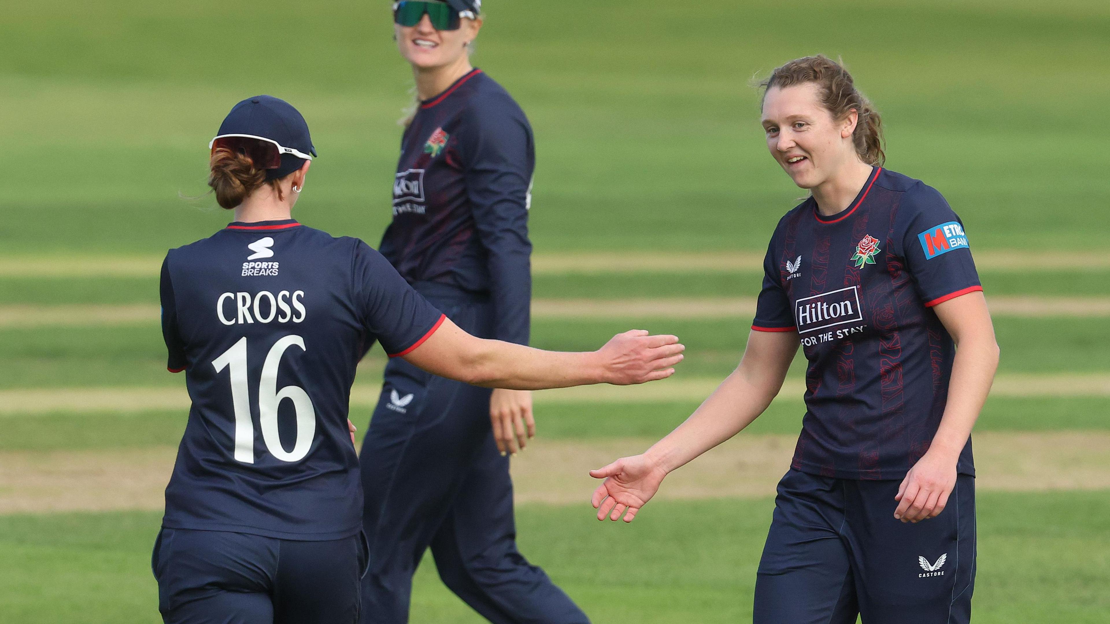 Kate Cross (left), wearing number 16, about to give a high-five to Grace Potts