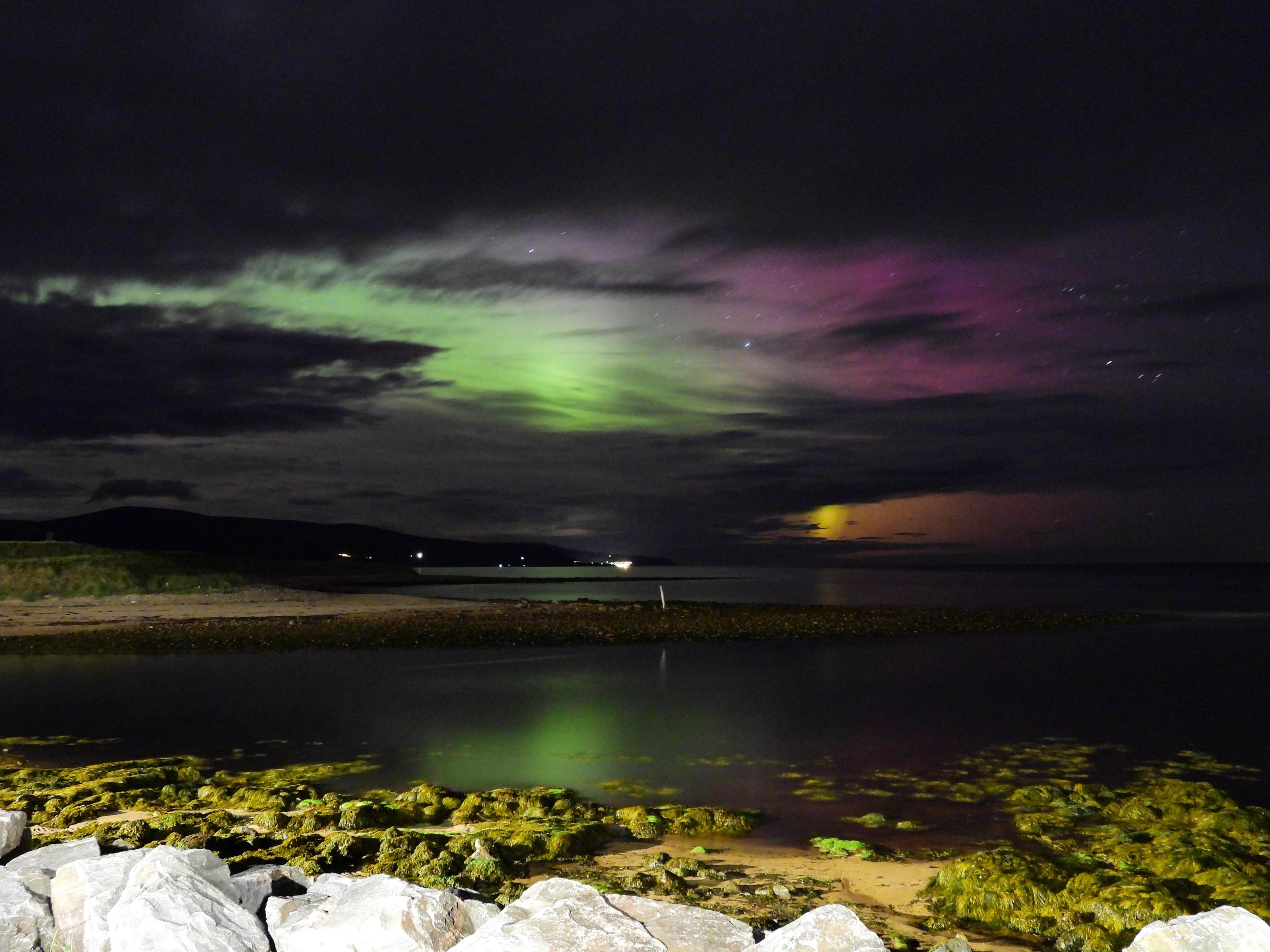 The northern lights showing through the clouds off Bora beach.