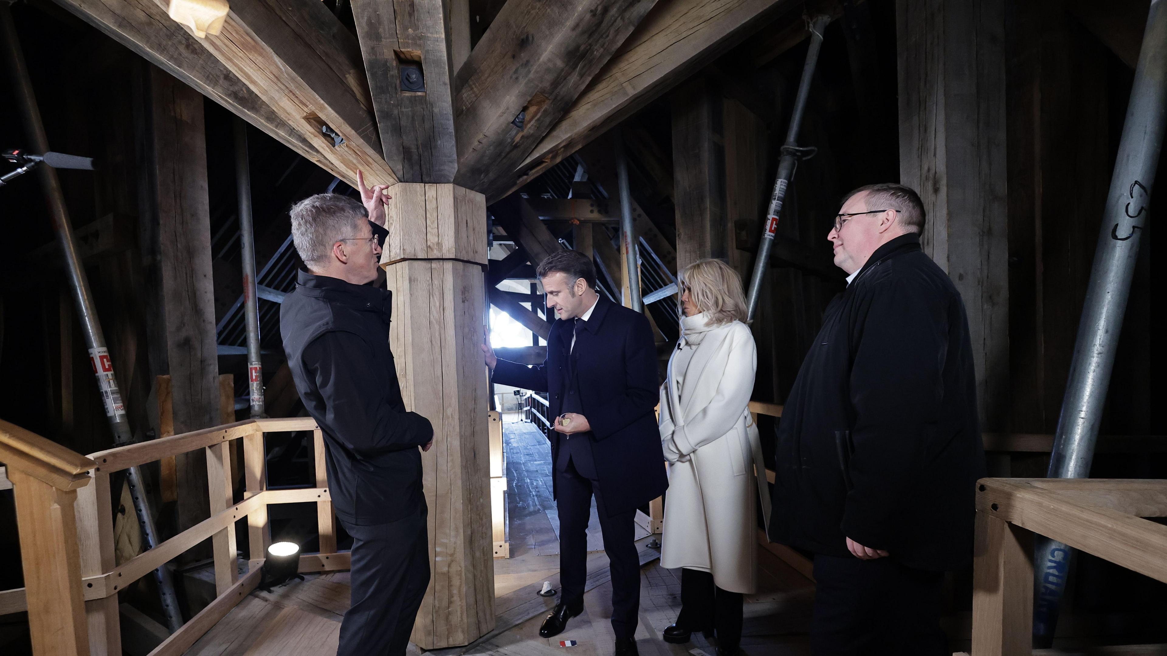 Image shows President Emmanuel Macron being shown the internal structure of the restored spire. 