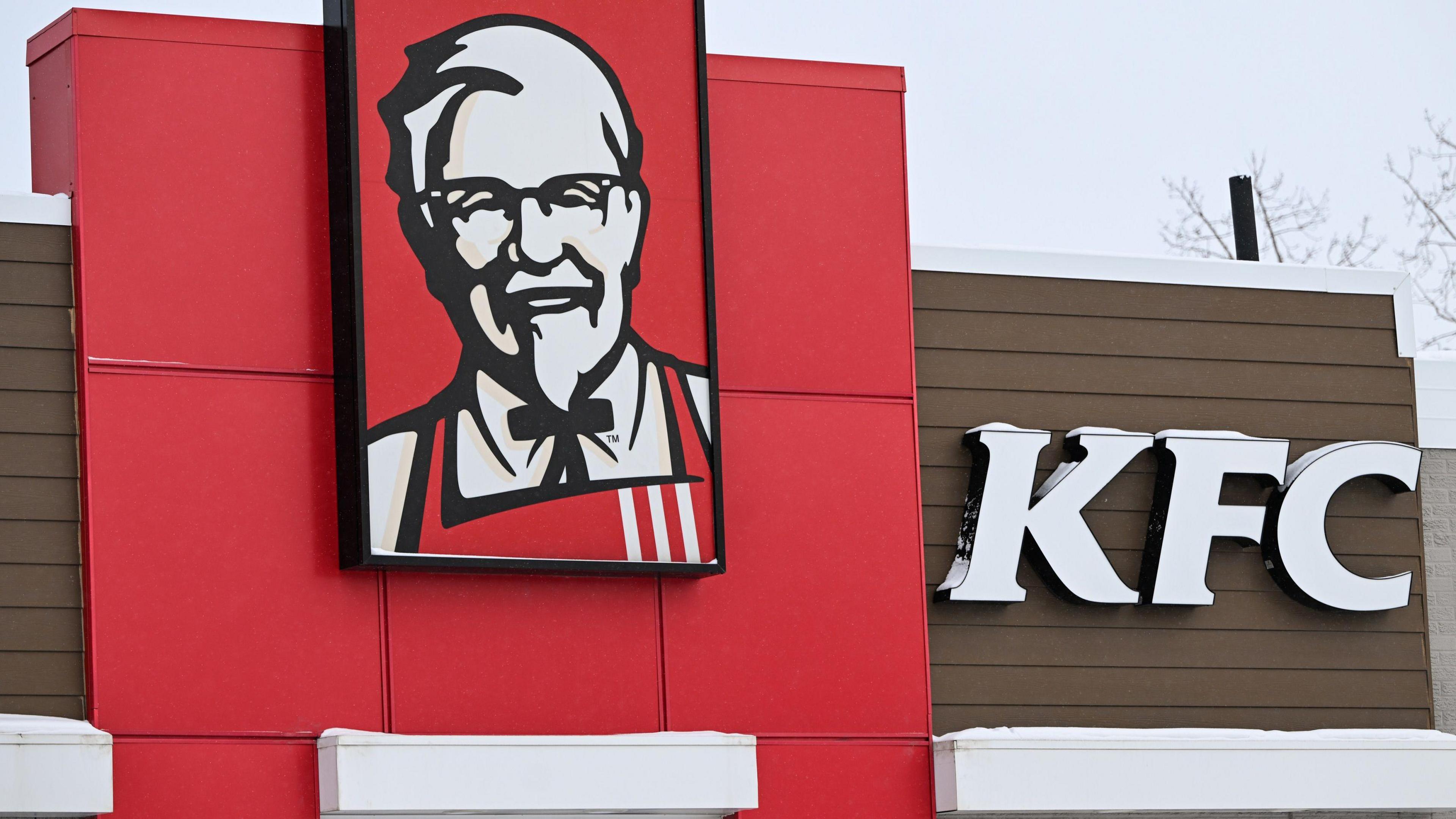 KFC logo displayed on the storefront of a KFC fast-food restaurant in Edmonton, Alberta, Canada.