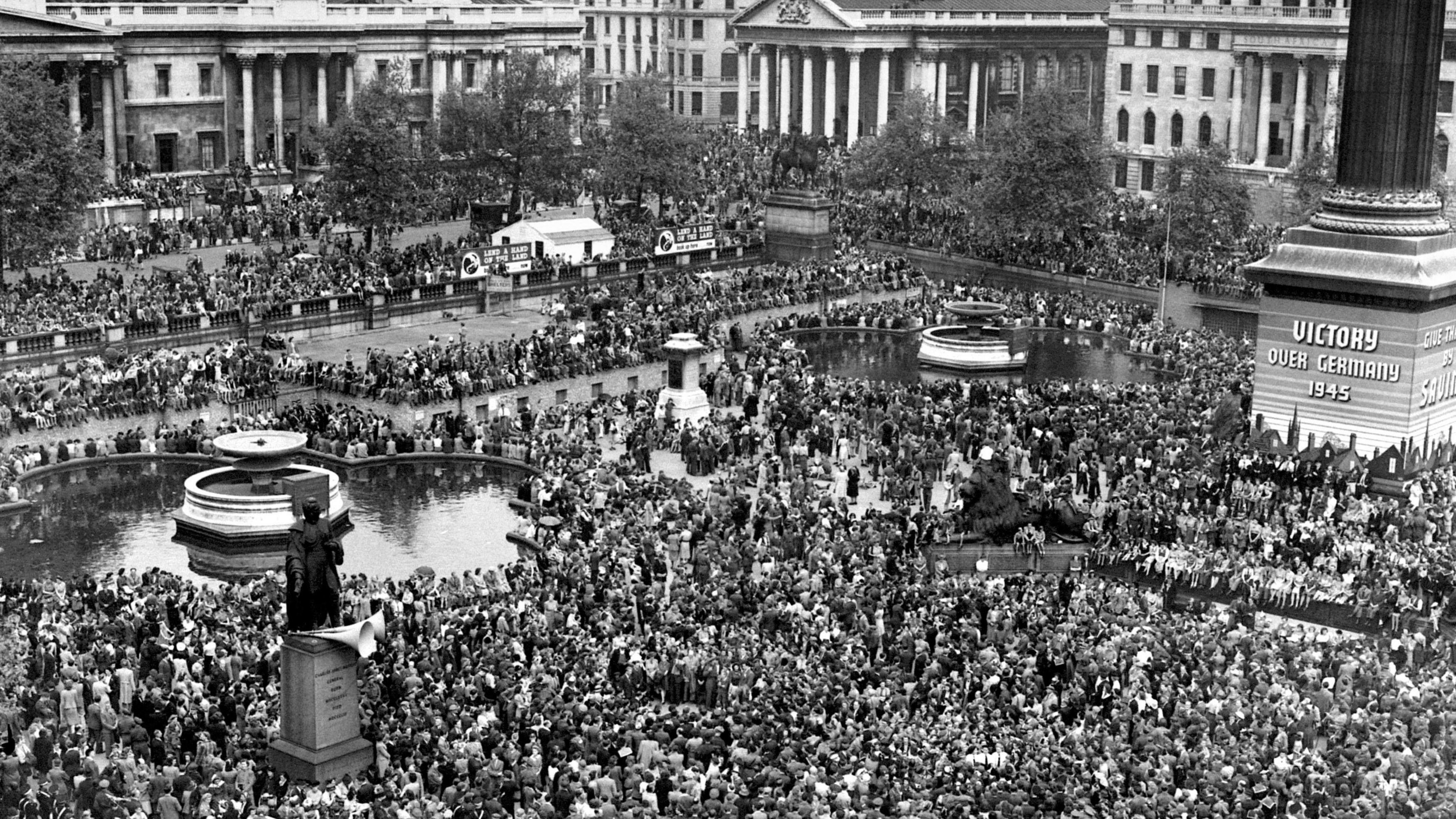 Huge crowds have descended on Trafalgar Square in London to celebrate VE Day. Hundreds of people are standing should to shoulder in this aerial-view image.