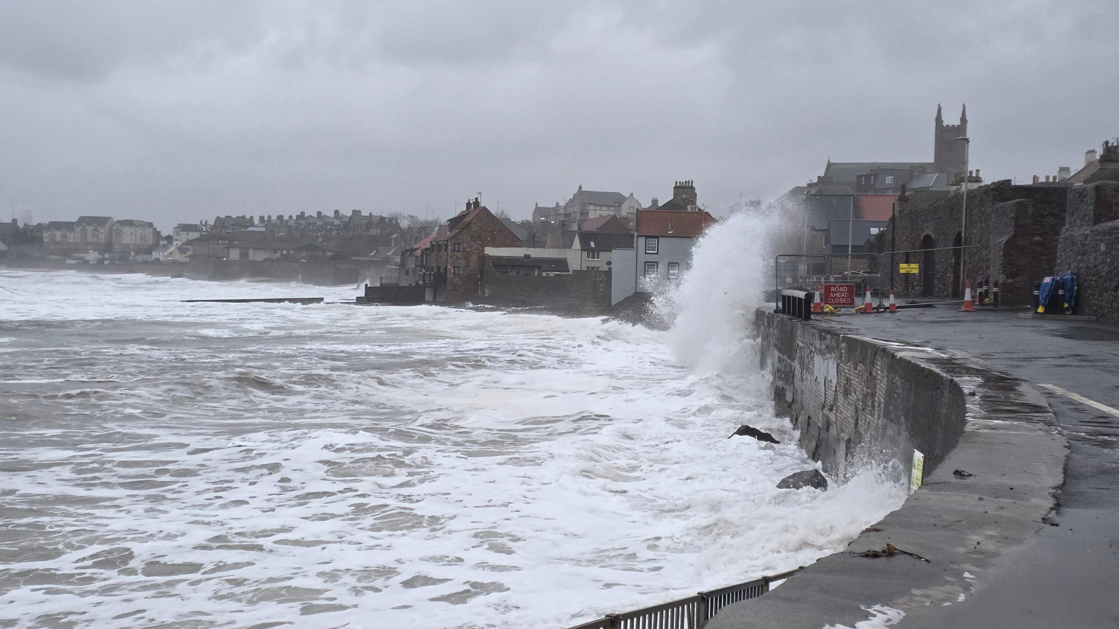 Wave crashes over promenade