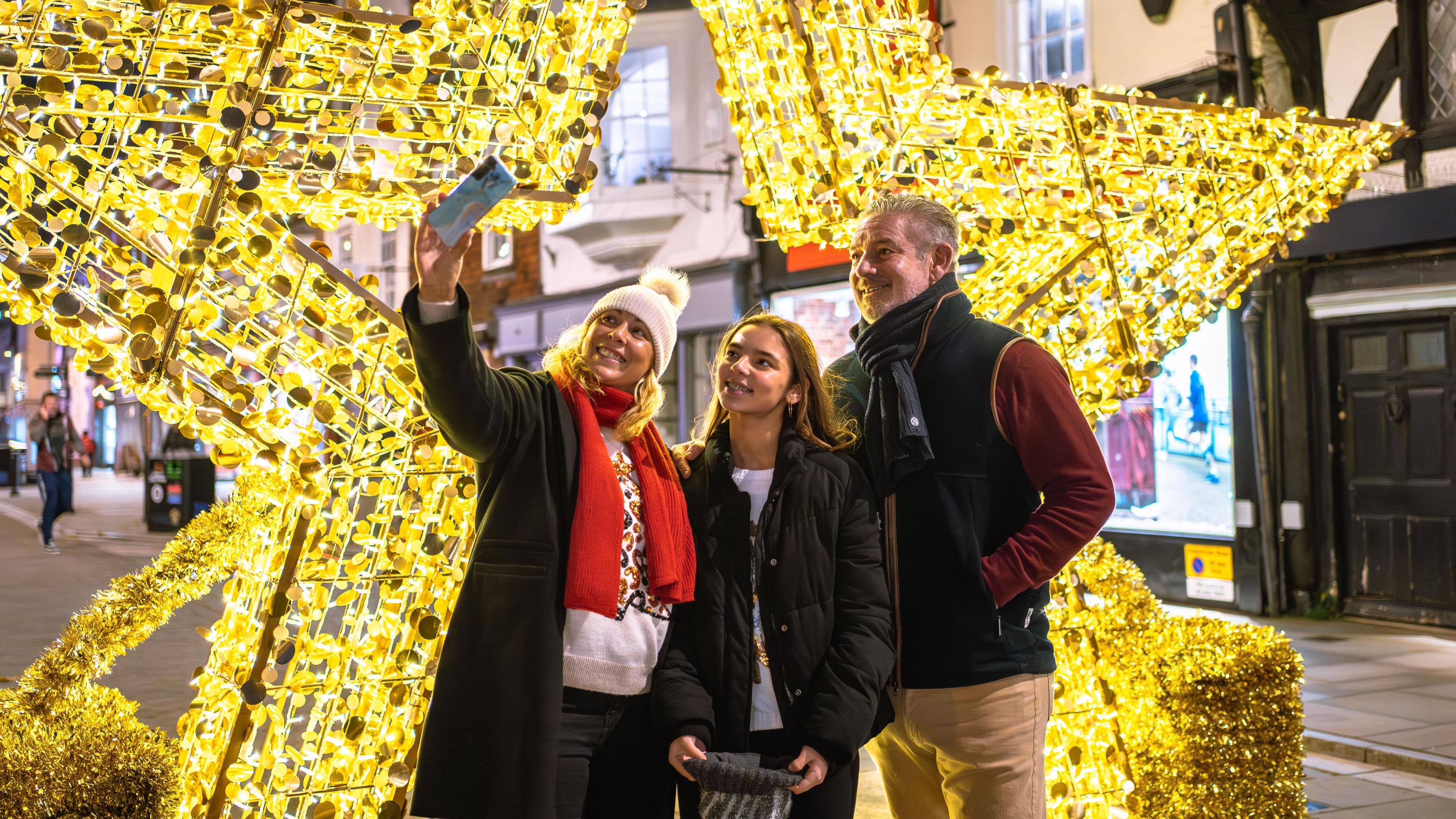 a family takes a selfie in front of Salisbury's light-up star