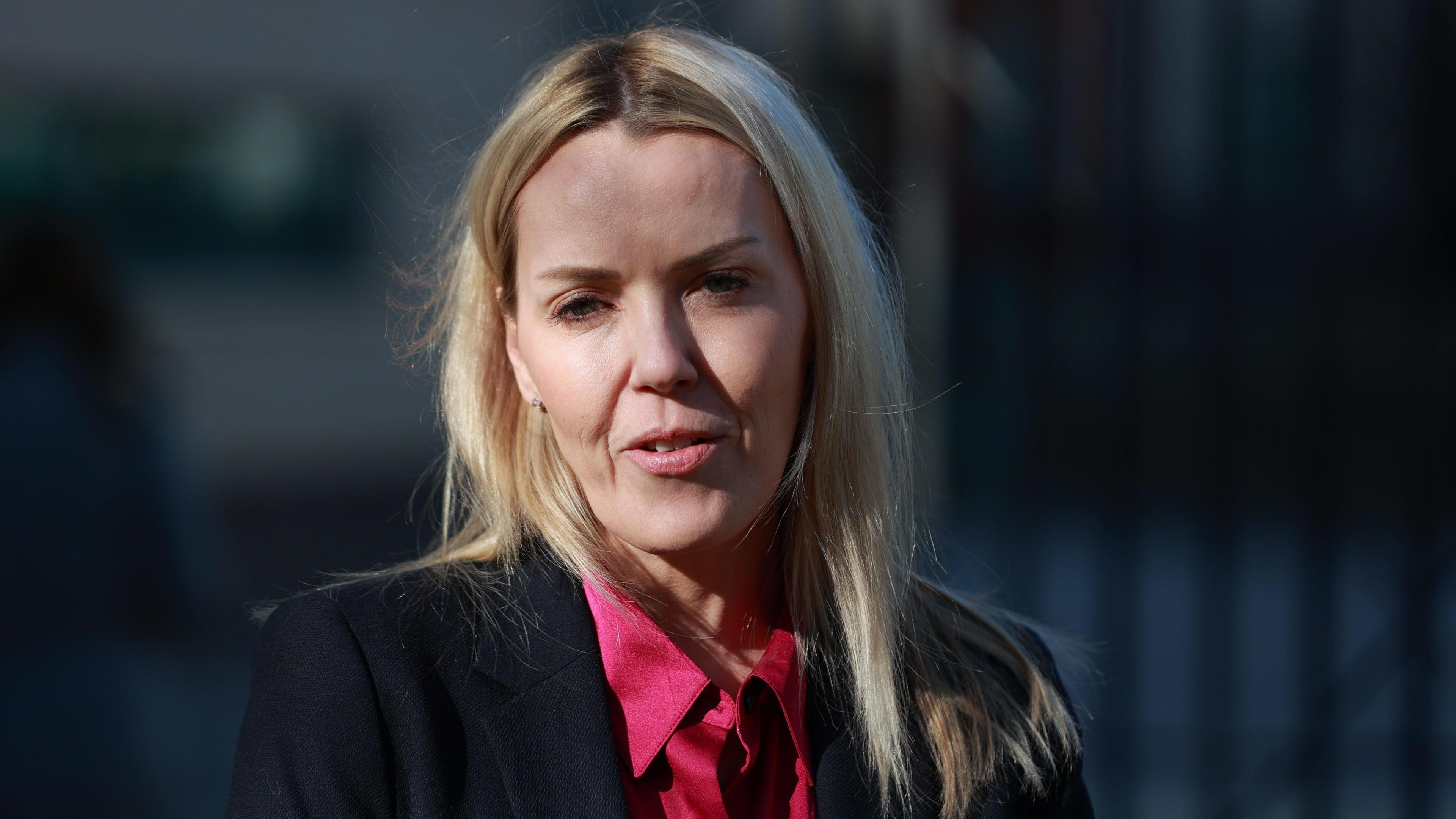 Jill Duffie, wearing a pink shirt and a black blazer