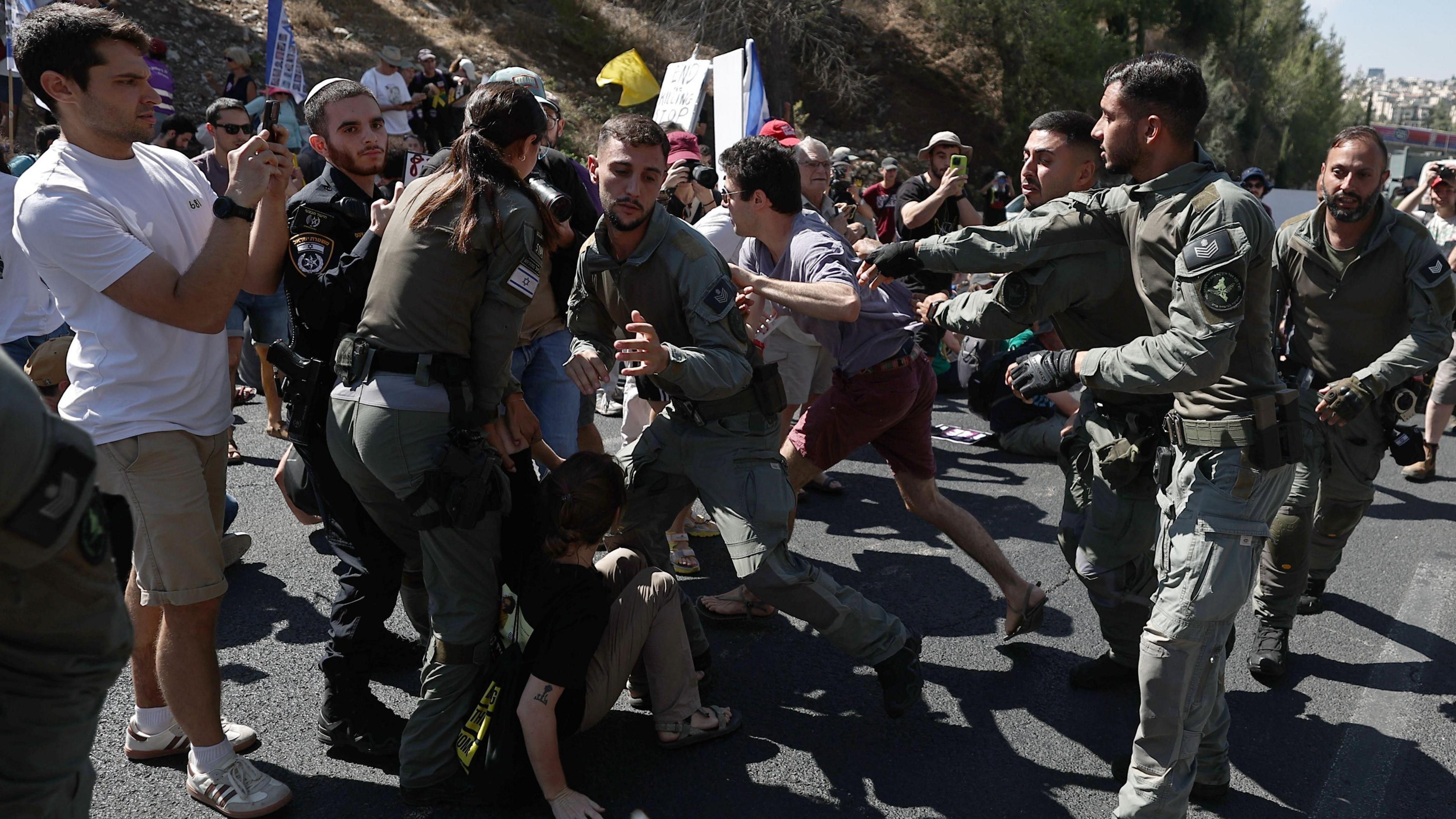 Israeli protesters are dragged away while blocking a major highway amid nationwide strike in Jerusalem on 17 August 2025.