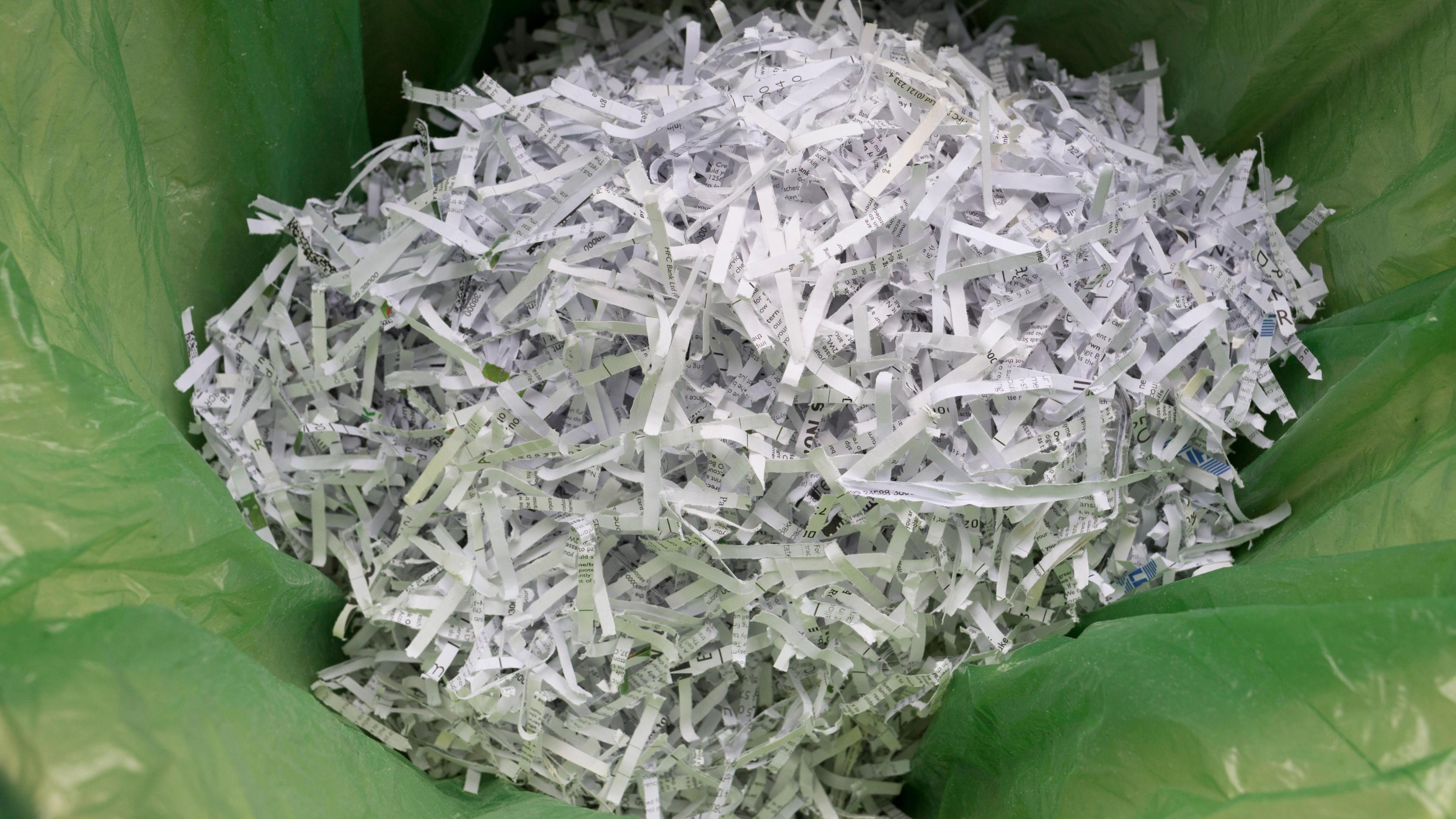 A pile of shredded documents inside a green bin bag
