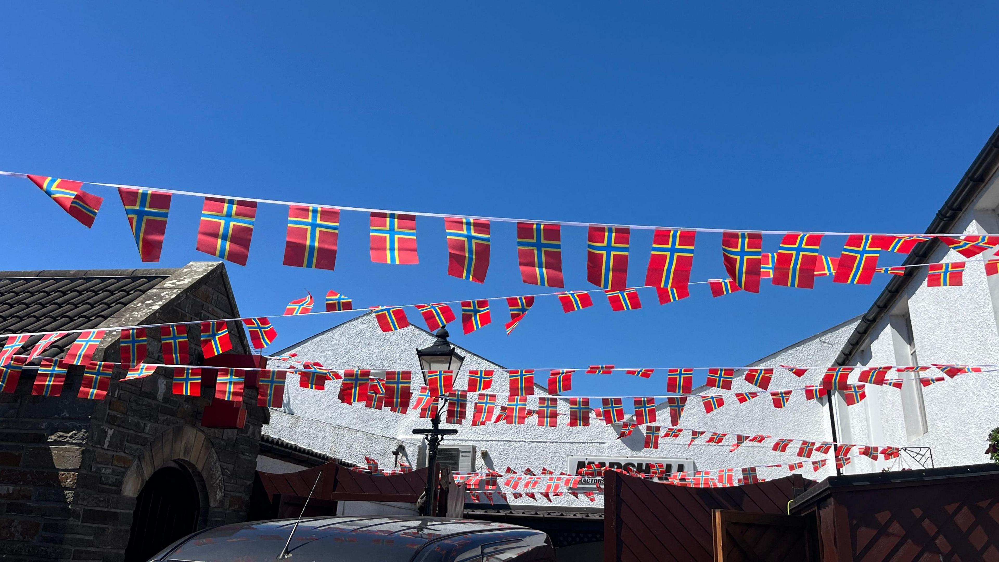 A string of Orkney flags, red, bule and yellow coloured.