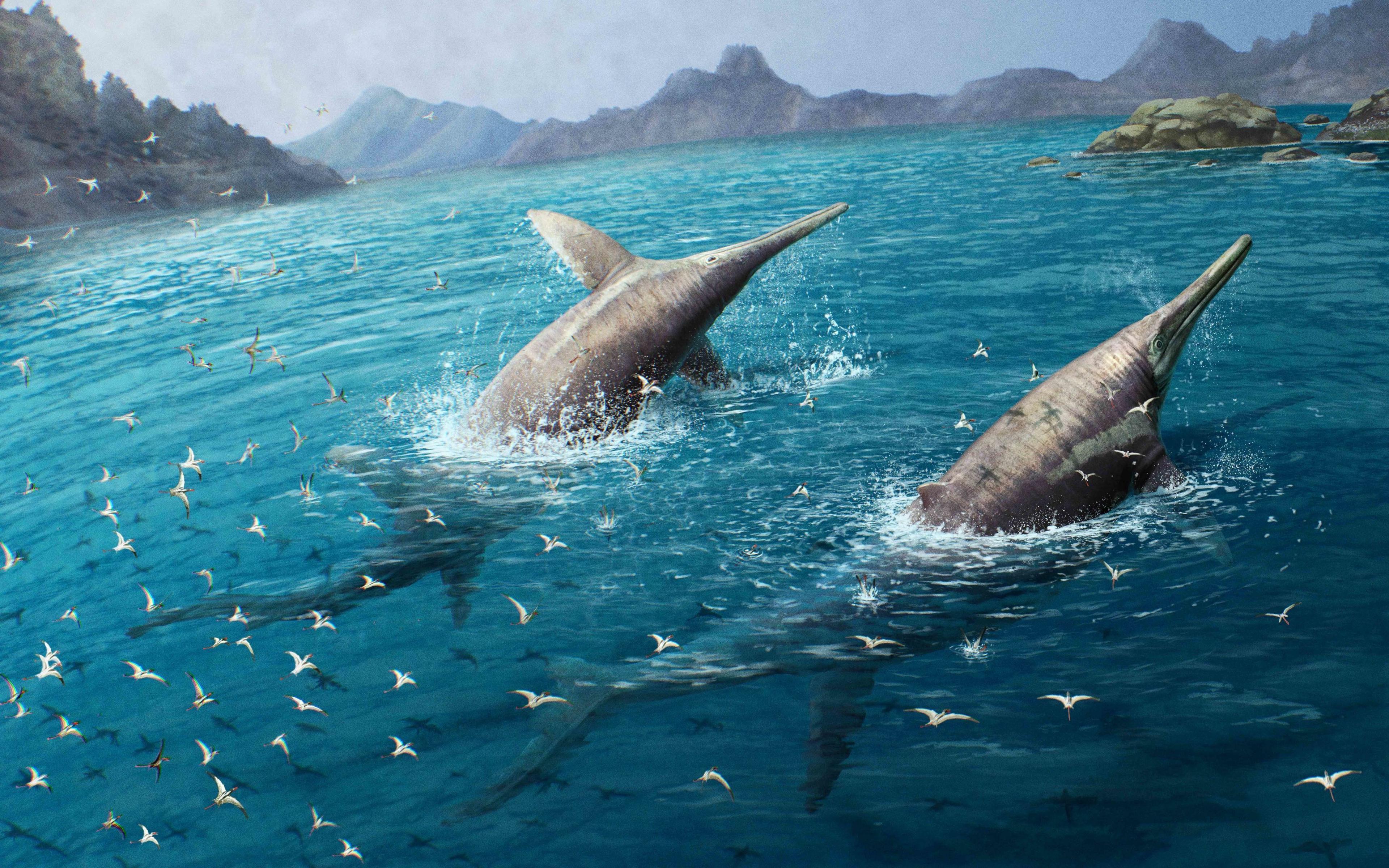 An illustration of two dolphin-like reptiles frolicking close to a coastline. Flying bird-like pterosaurs follow closely behind, showing the sheer scale of the pair