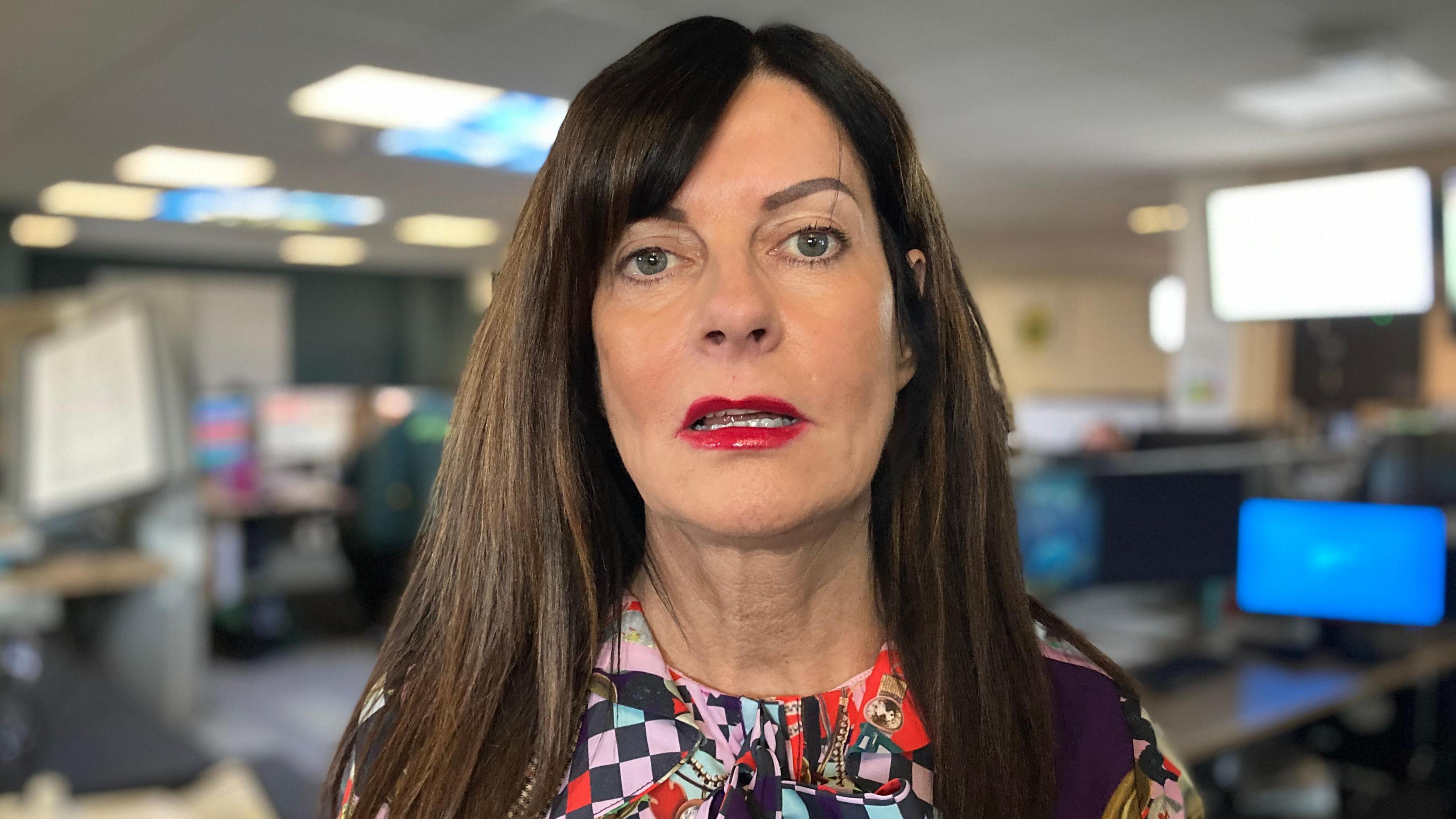 Stephanie Patten - a woman with long, dark hair wearing a colourful pattered top. She is looking at the camera with her mouth slightly open.