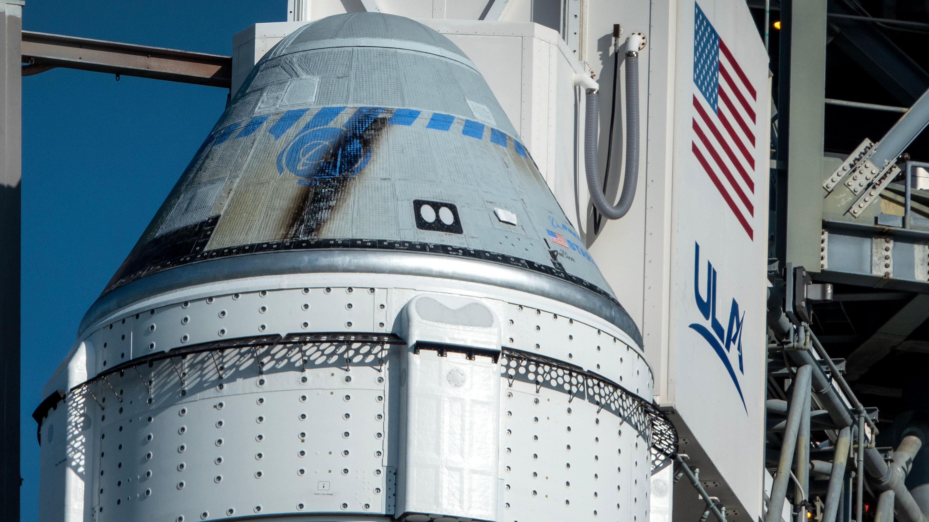 A grey capsule sitting at the top of a space rocket, in a conical shape