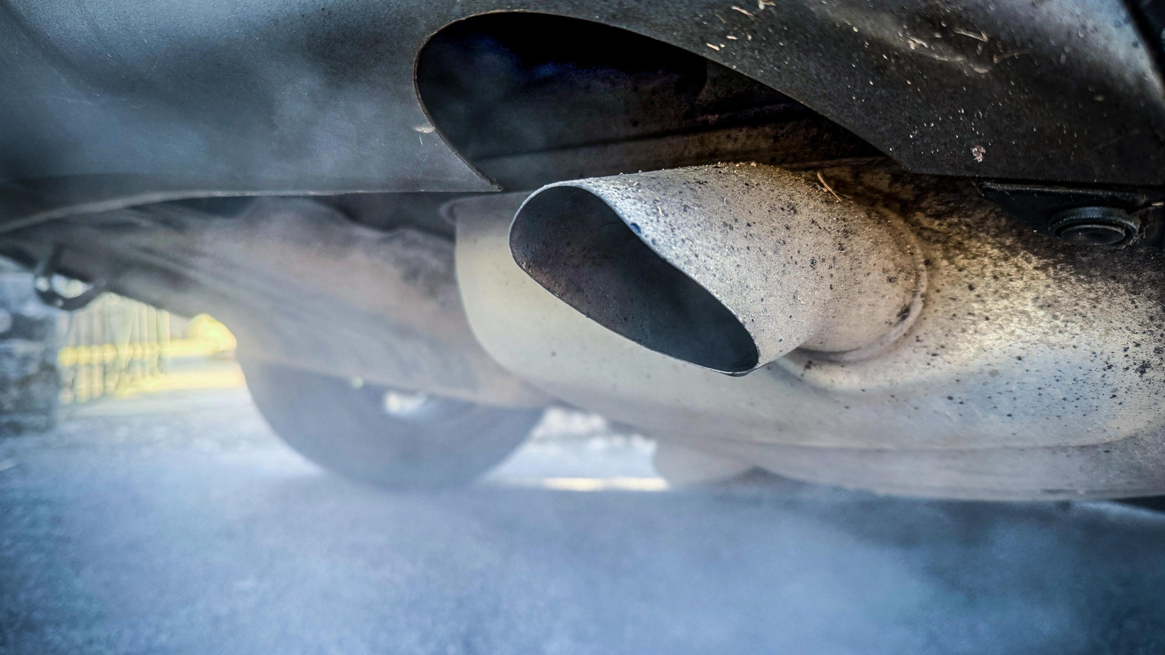 Close up of car exhaust pumping out fumes