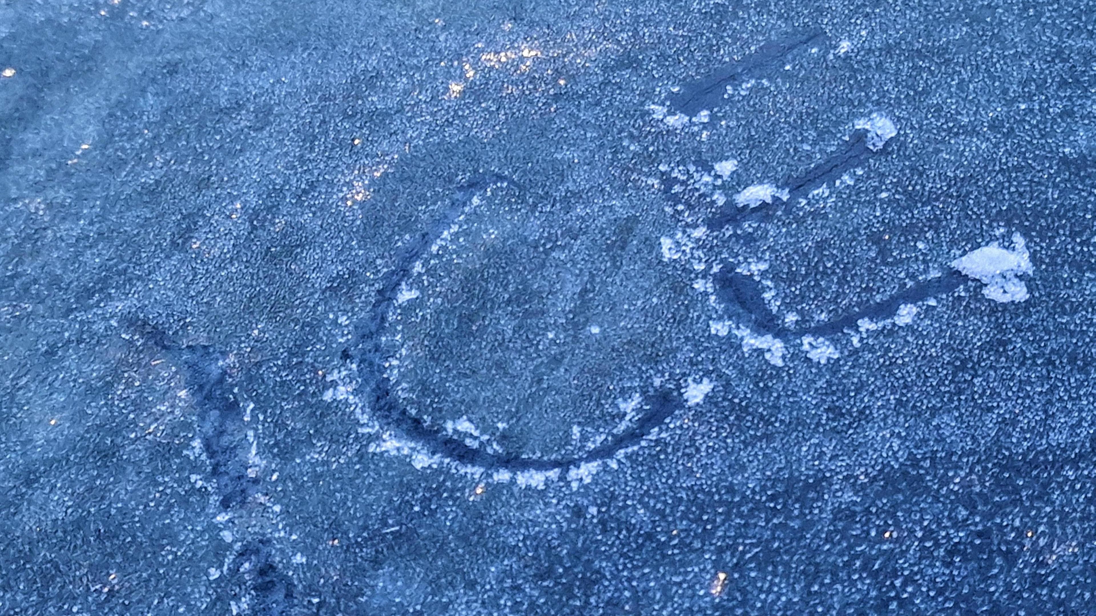 An icy surface is pictured which someone has written the word 'ice' into.