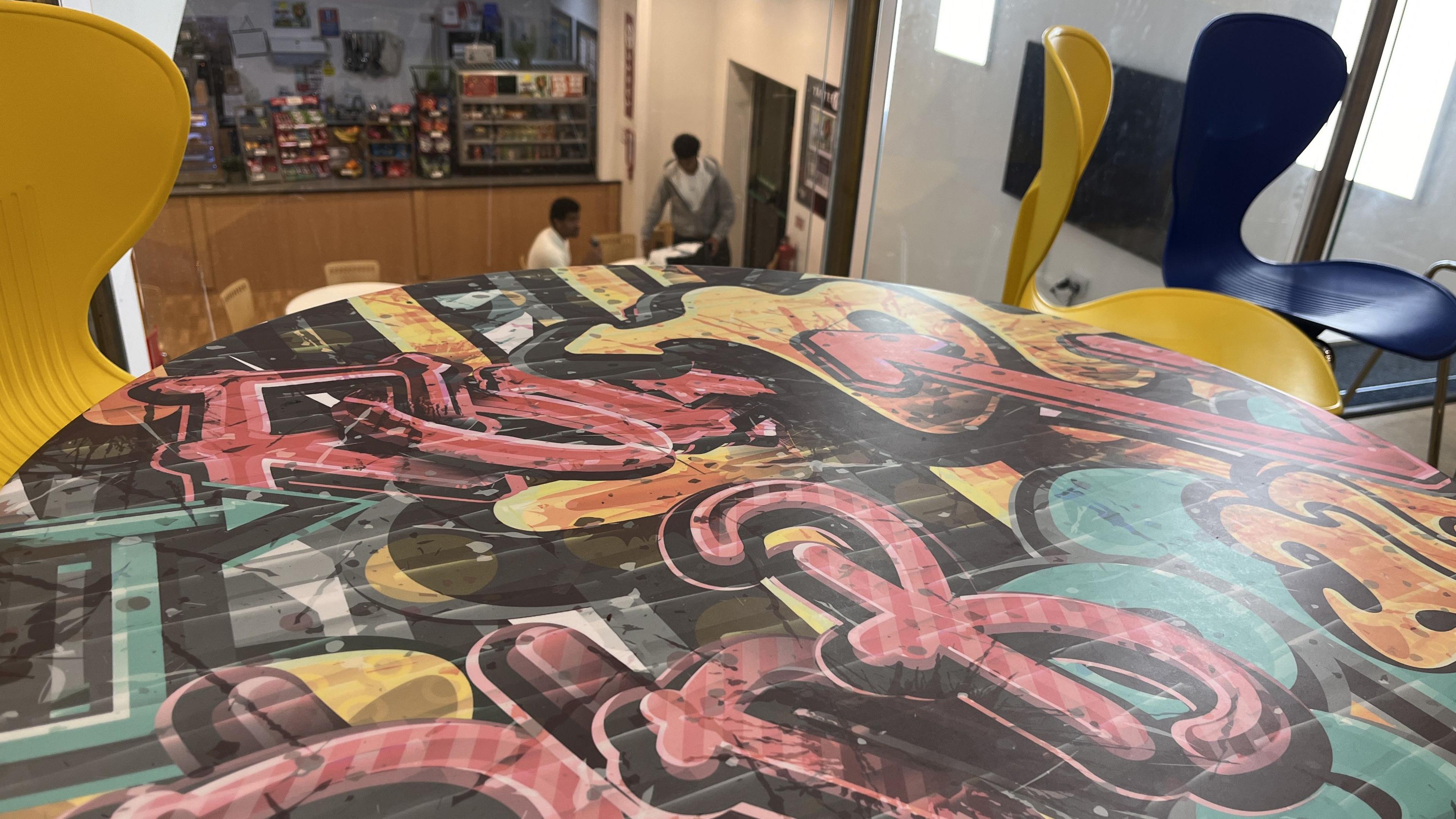 A table within Salisbury Sixth Form College that's painted in a street art graffiti