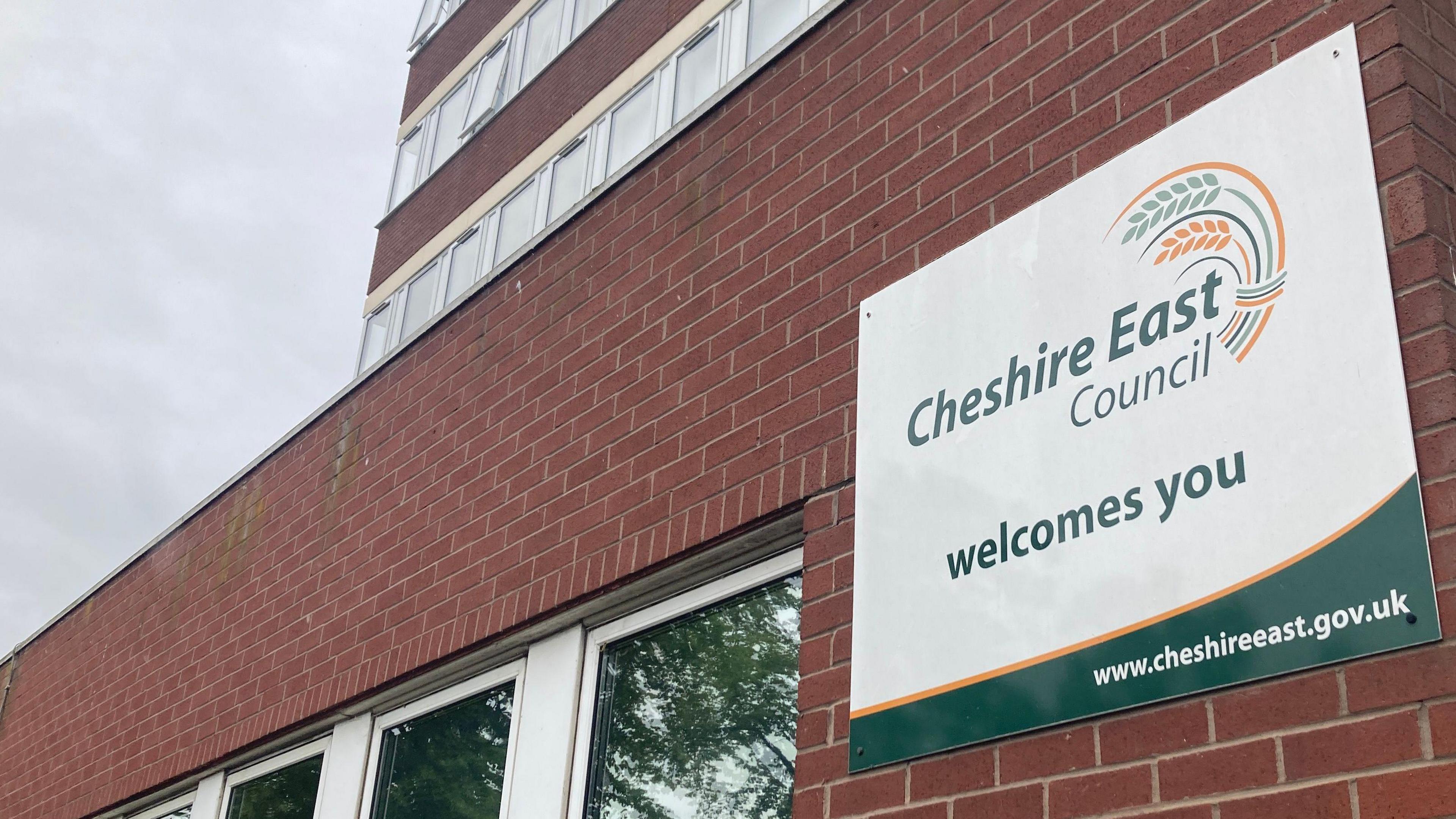 View of Cheshire East Council's headquarters, focused on a sign on saying Cheshire East Council welcomes you