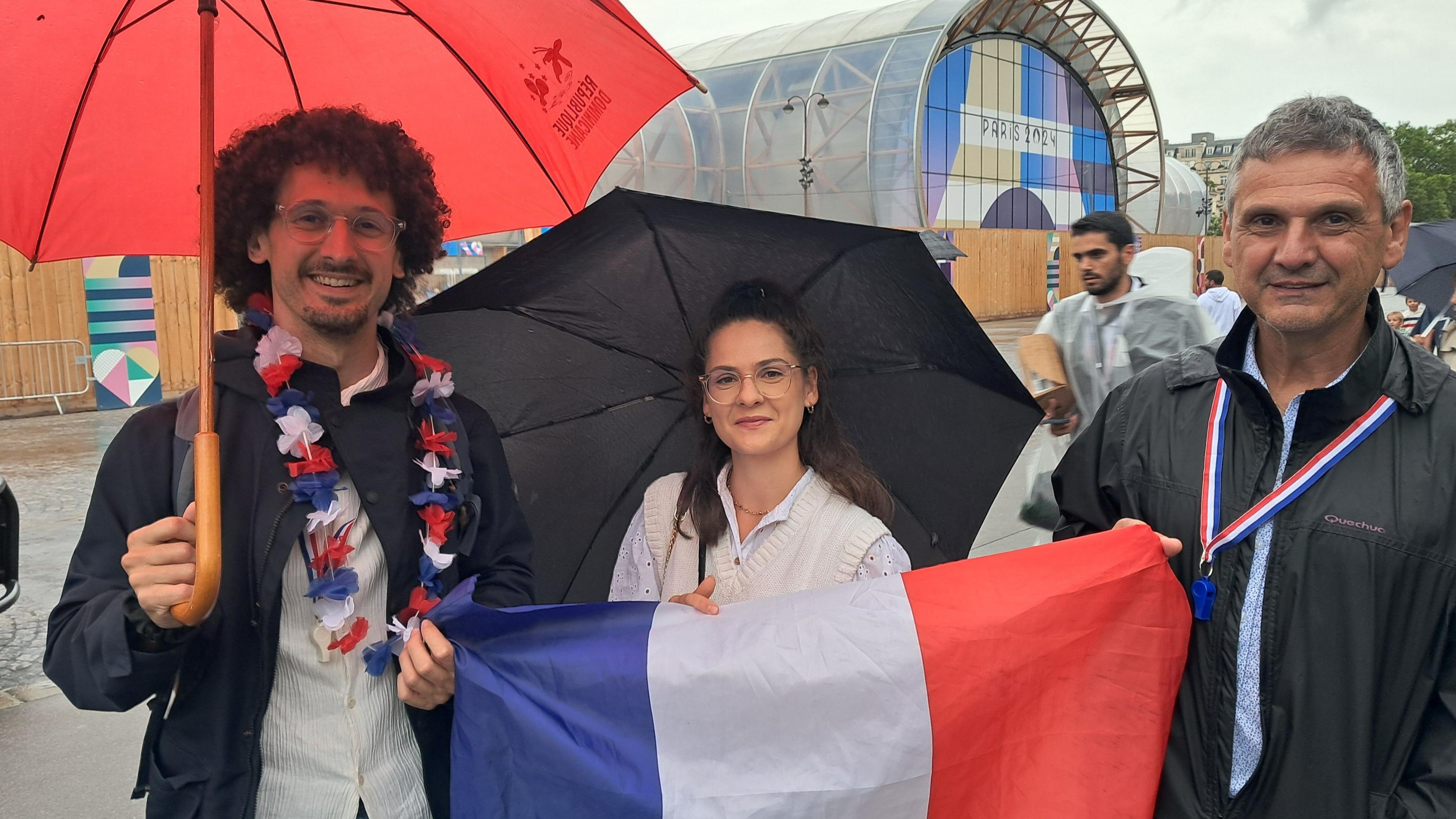 Alexandre holds a French flag with two companions