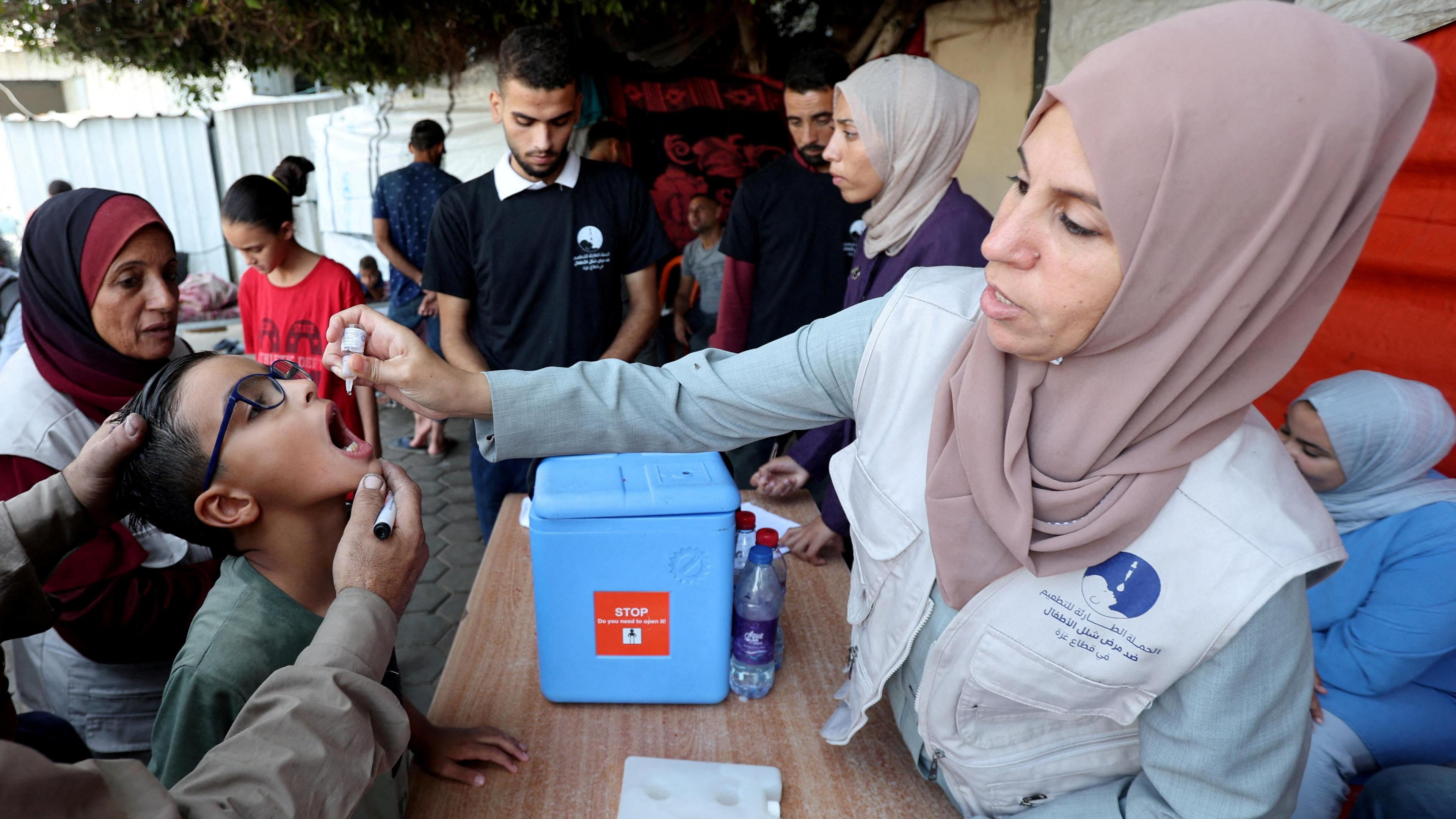 A healthcare worker gives an oral polio vaccine to a child in Deir al-Balah, central Gaza (15 October 2024)