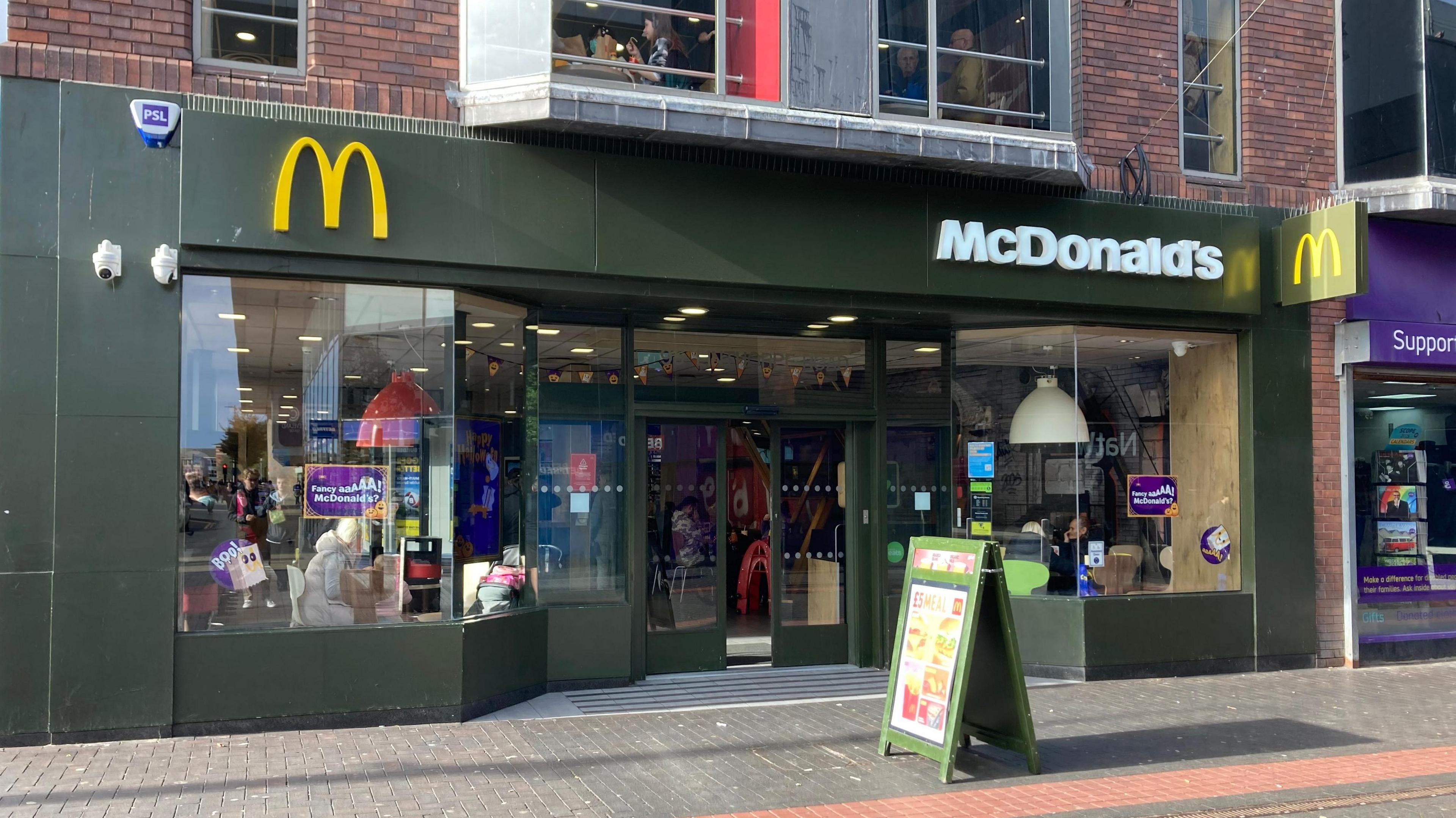 A general view of Middlesbrough's McDonald's branch from outside. The fast food restaurant is on the ground floor of a high street building and people can be seen sat at tables inside.